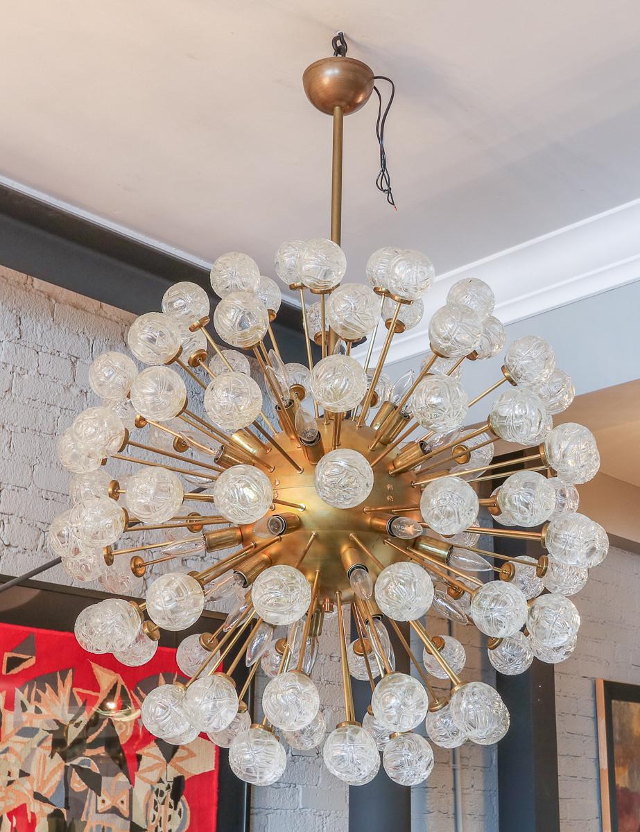 Starburst sputnik chandelier from the 1980s with a brass frame and rose flower shaped clear glass.