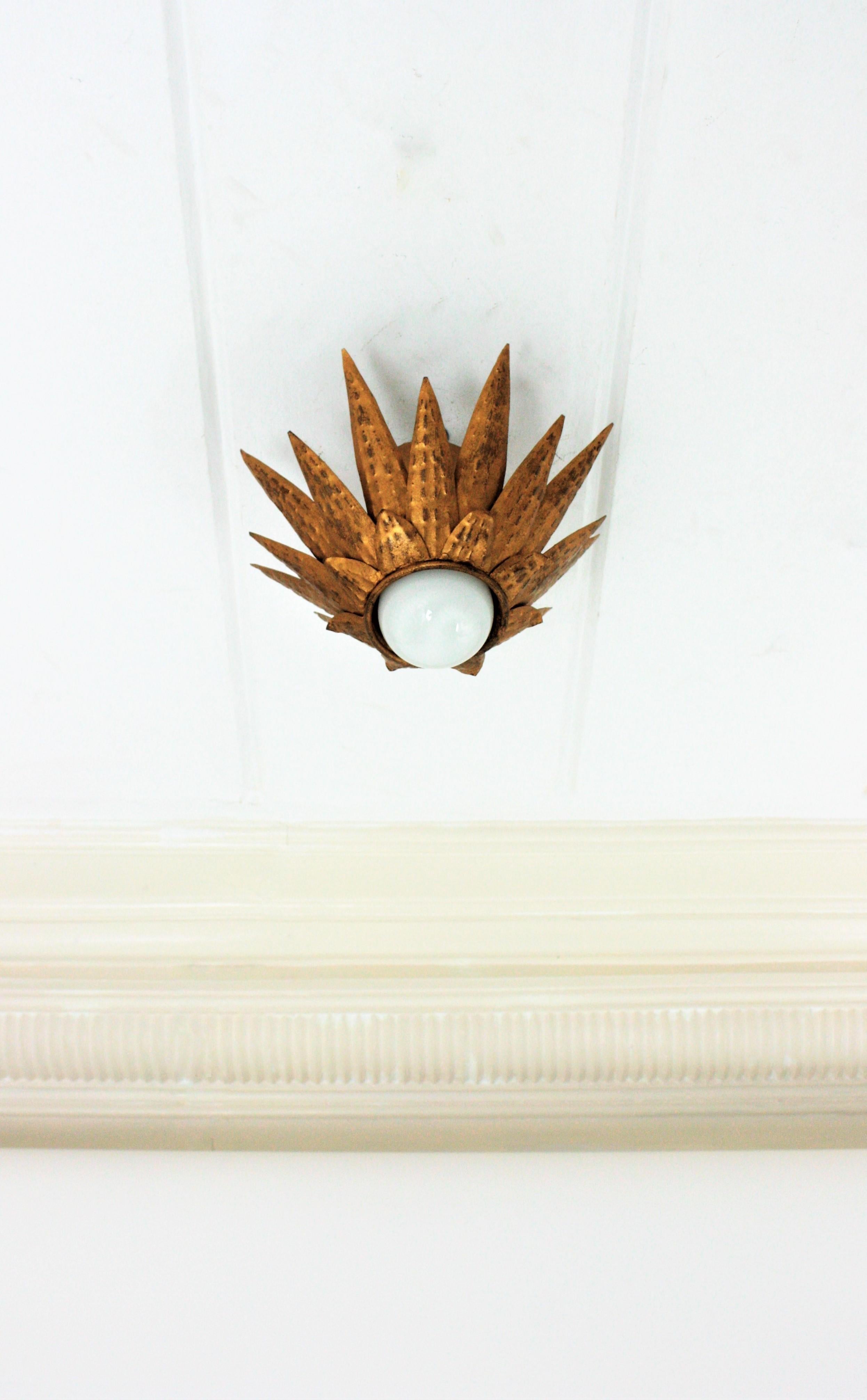 Brutalist sunburst starburst light fixture, iron, gold leaf, France, 1950s
This triple layered flush mount has a richly hammer work thorough. It has a terrific aged patina showing its original gold leaf gilding.
This starburst ceiling light can be