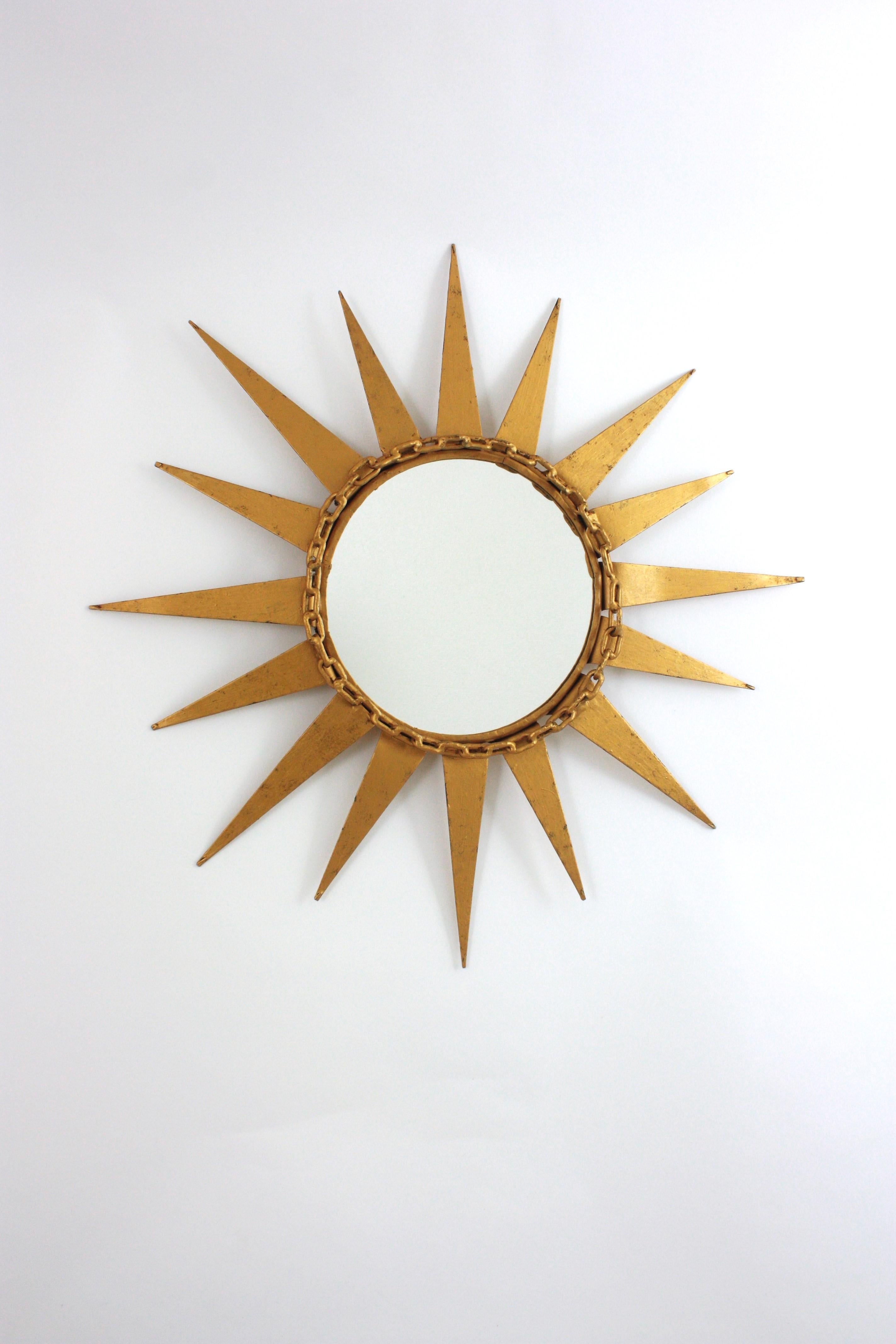 Brutalist Starburst Sunburst Mirror with Chain Links Details, Wrought Gilt Iron, Spain, 1950s
Rare find.
This starburst mirror was manufactured at the Mid-Century Modern period and combines Midcentury and Brutalist accents.
The star shaped frame is