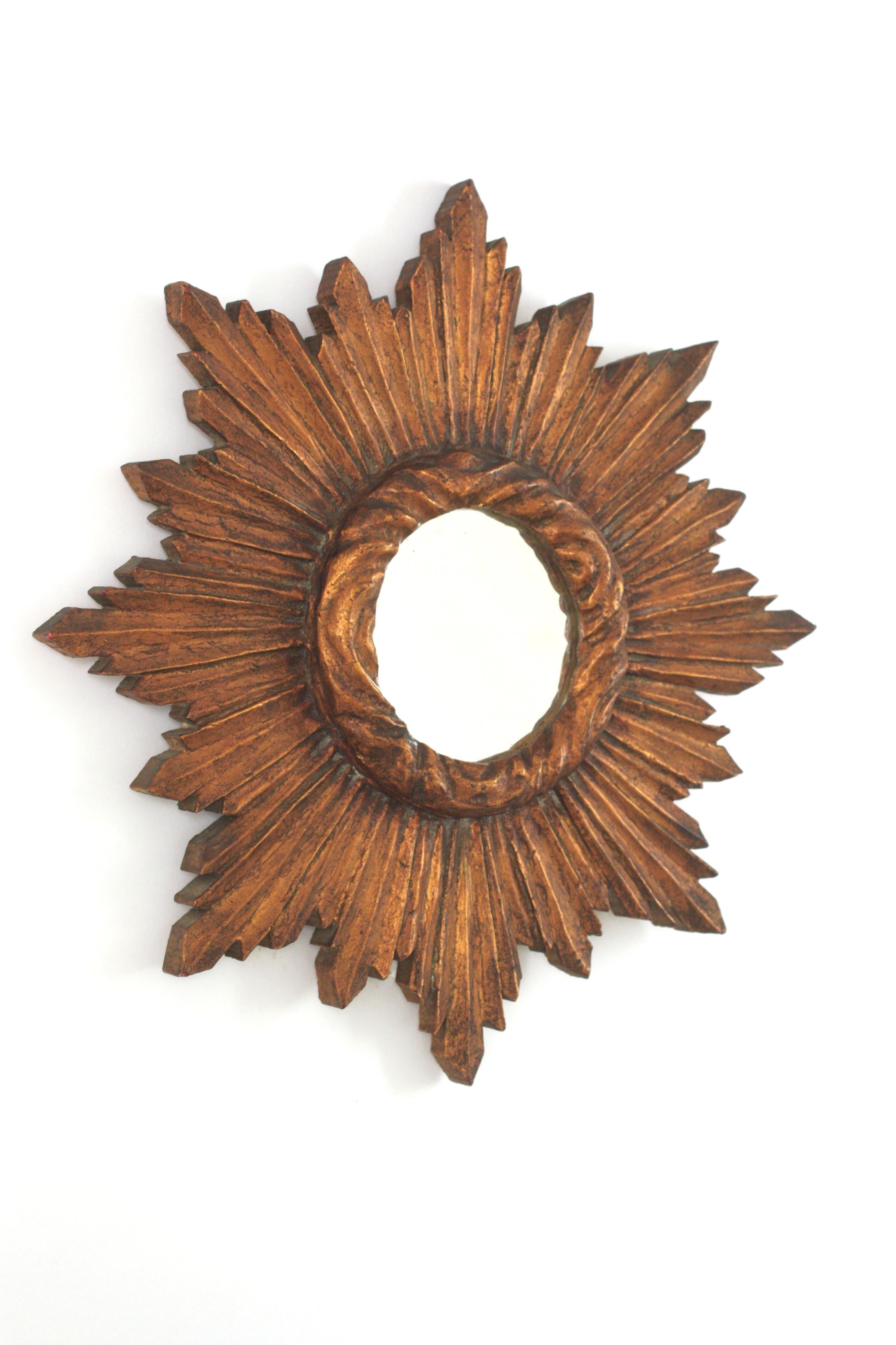 Splendido specchio a raggiera in legno dorato, Spagna, 1940-1950.
Questo specchio da parete a raggiera realizzato in stile Mid-Century Modern è caratterizzato da una cornice riccamente intagliata a raggiera. 
Stile barocco.
Doratura originale a