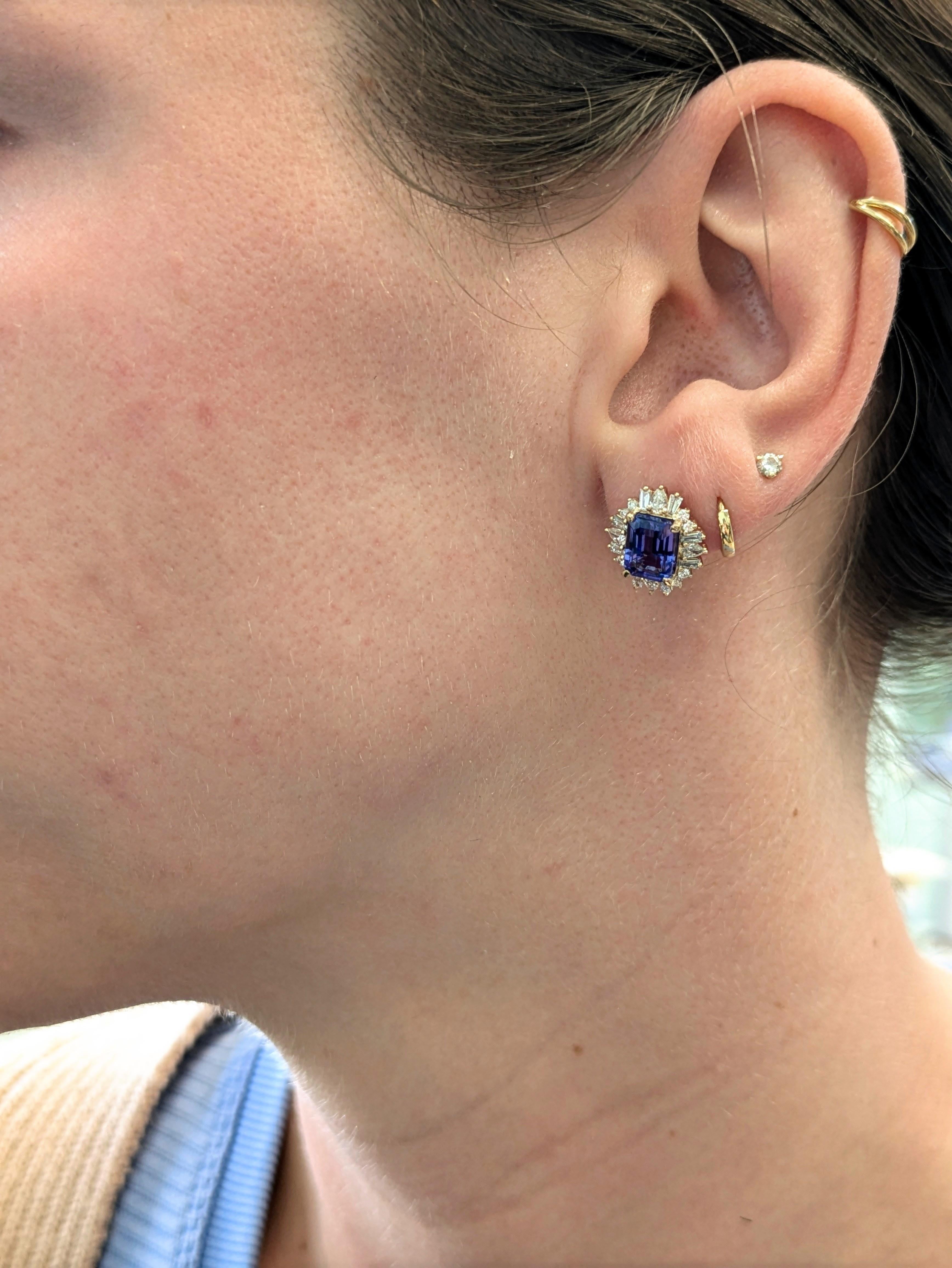 Una vivida tanzanite dal taglio smeraldo di 3,57 carati domina l'attenzione nel cuore di questi orecchini a stella, circondati da un'aureola abbagliante di diamanti estratti dalla terra in forme miste. Incastonato in oro giallo massiccio 14 carati,