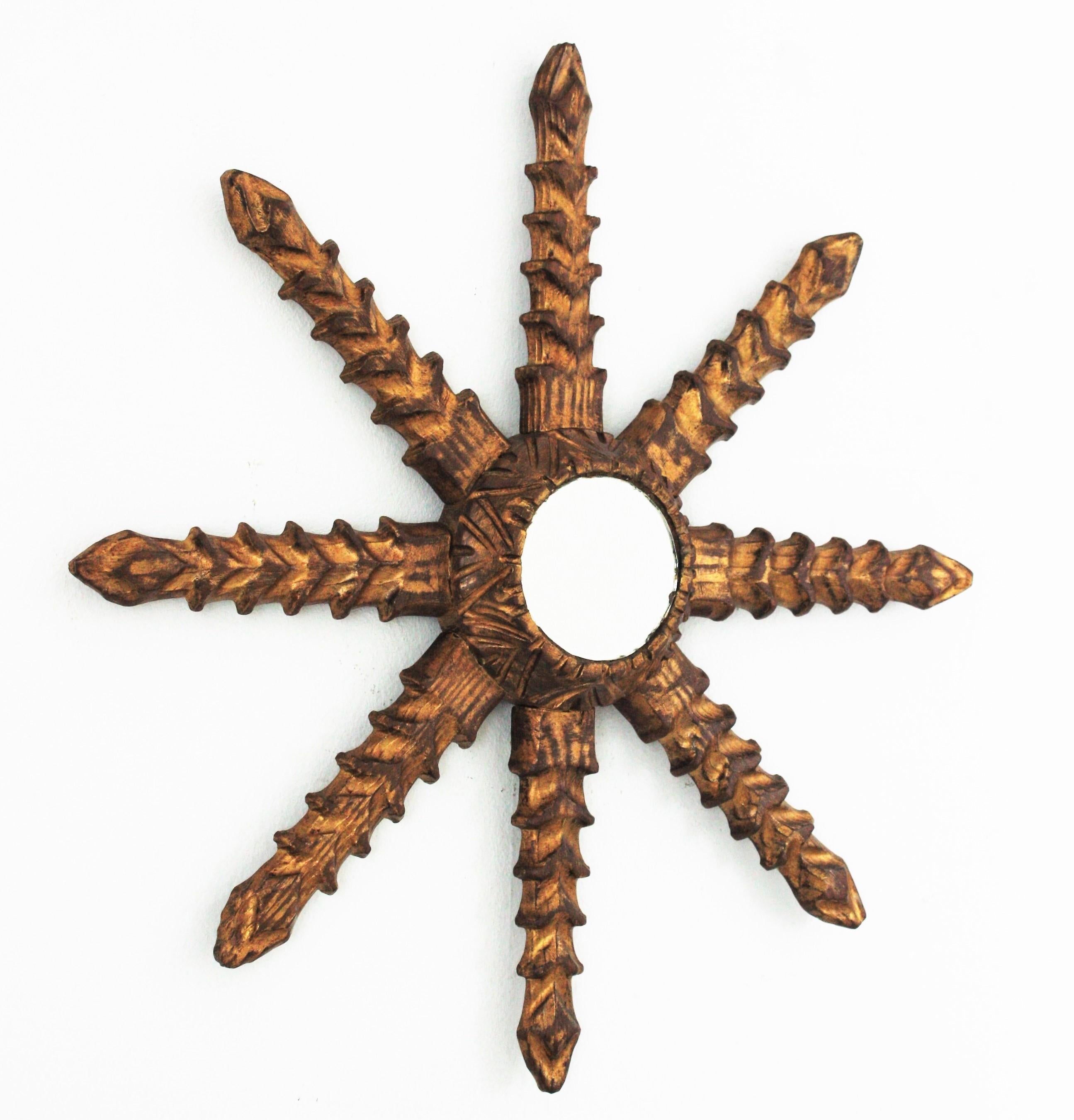 Starburst Sunburst Mirror, Carved Giltwood
A beautiful carved giltwood starburst wall mirror, Spain, 1950s-1960s.
This hand carved star shaped sunburst mirror has an unusual design with thick jagged rays.
Carved wood patinated in gilded