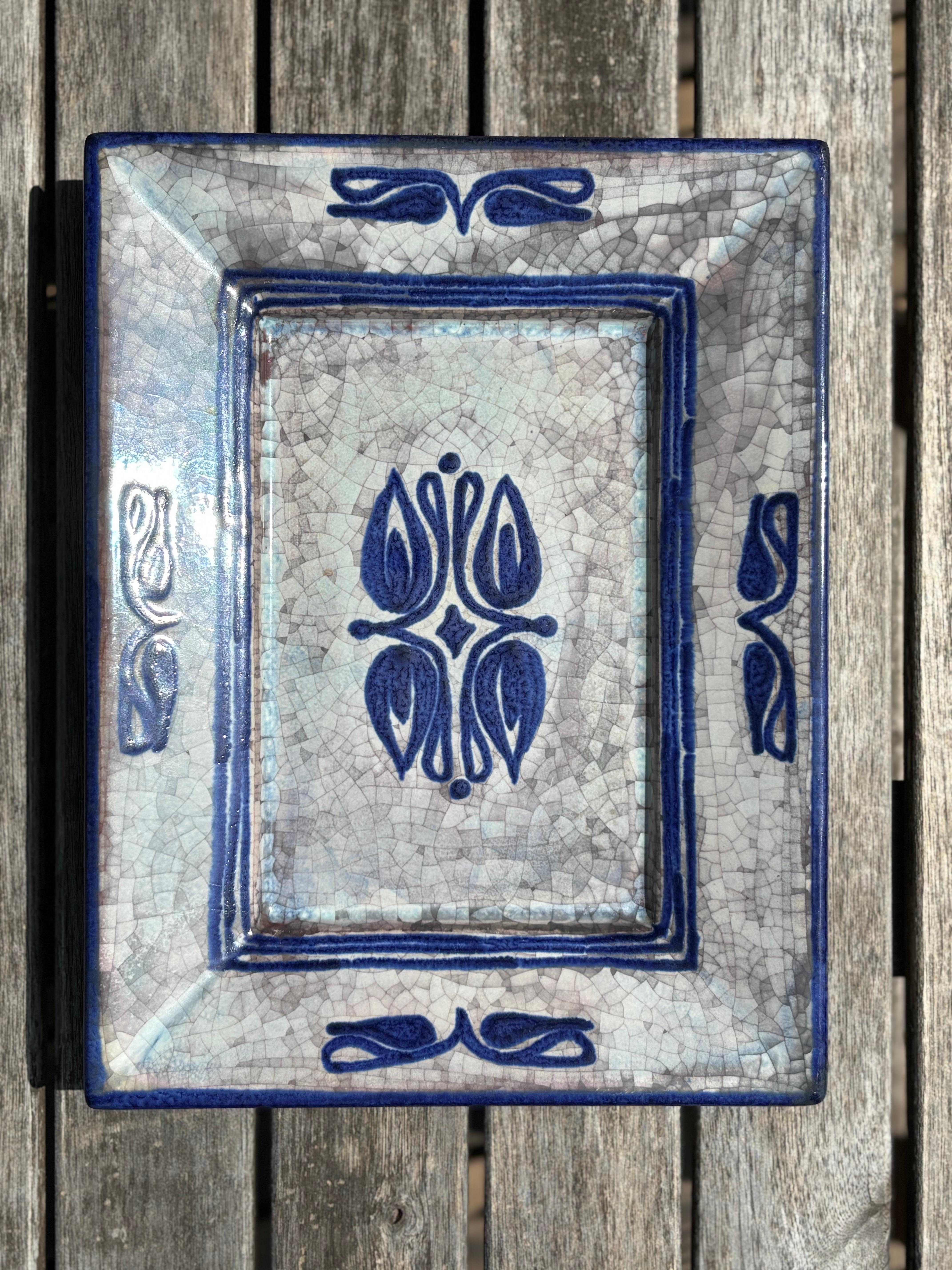 Handmade Danish midcentury modern decorative vide-poche plate. Decorated by hand in blue lines and floral shapes over white and warm gray persia crackle glaze. Designed by Marianne Starck for Michael Andersen & Son, and manufactured on the island of