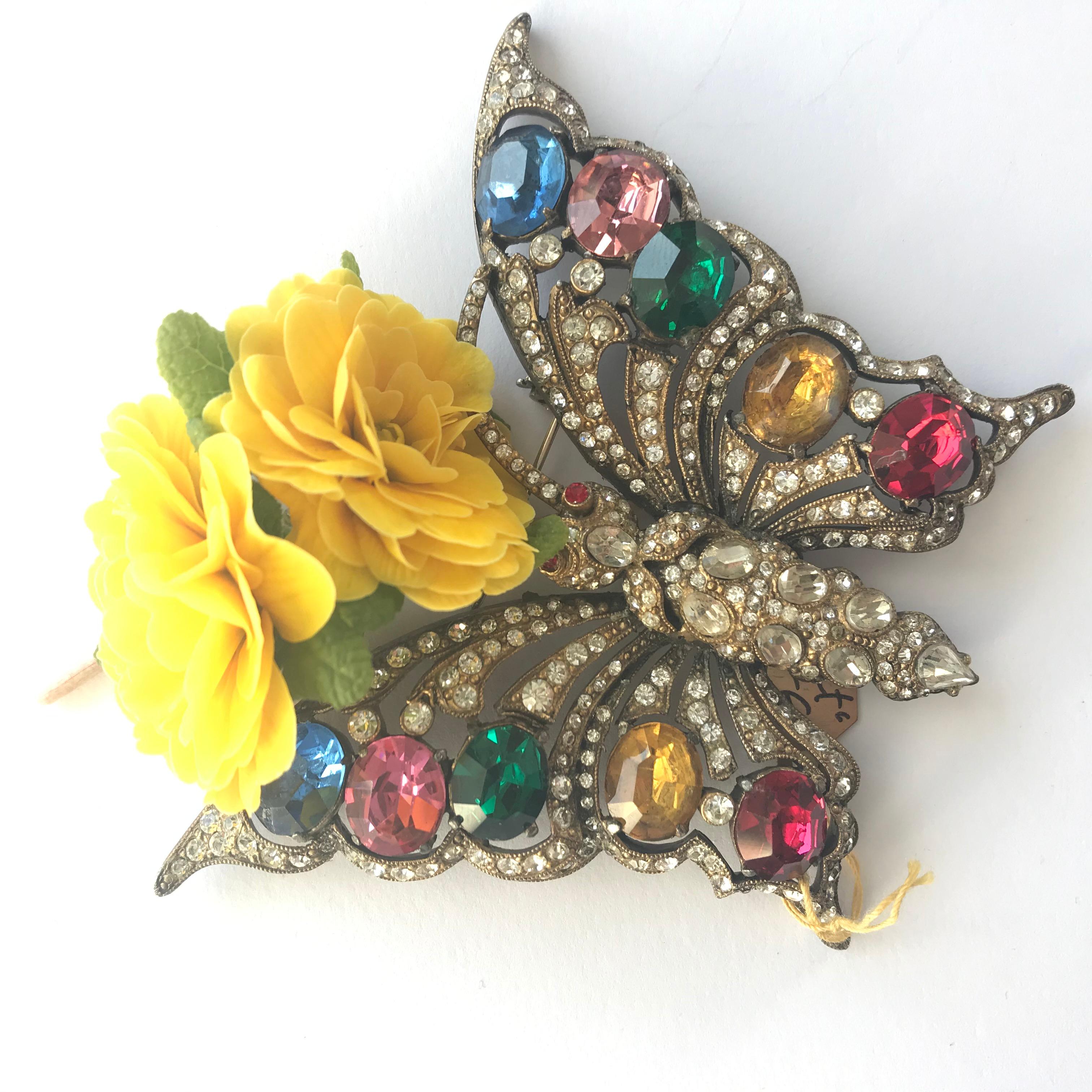 A wonderful rhinestone brooch in the shape of a butterfly. The whole brooch is set with 10 large cut, colorful rhinestones. The rest of the body is completely covered with small to large clear rhinestones. A typical work from the 1930/40s work USA,