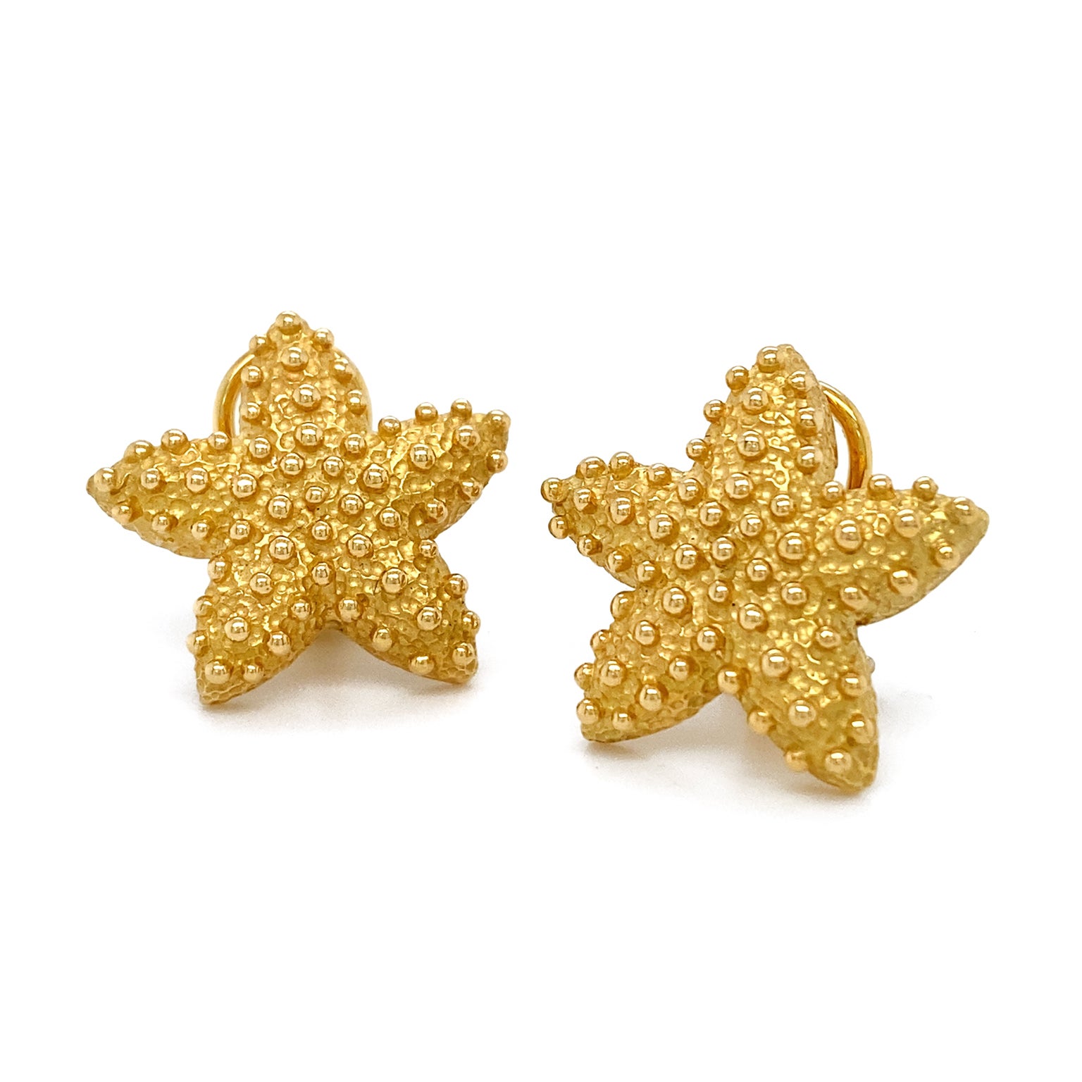 Gold enlivens these starfish earrings. The base is in the silhouette of the sea animal and has been given texture for both realism and precision. Smooth globes of the metal are dispersed over this to complete the oceanic spirit of the design.