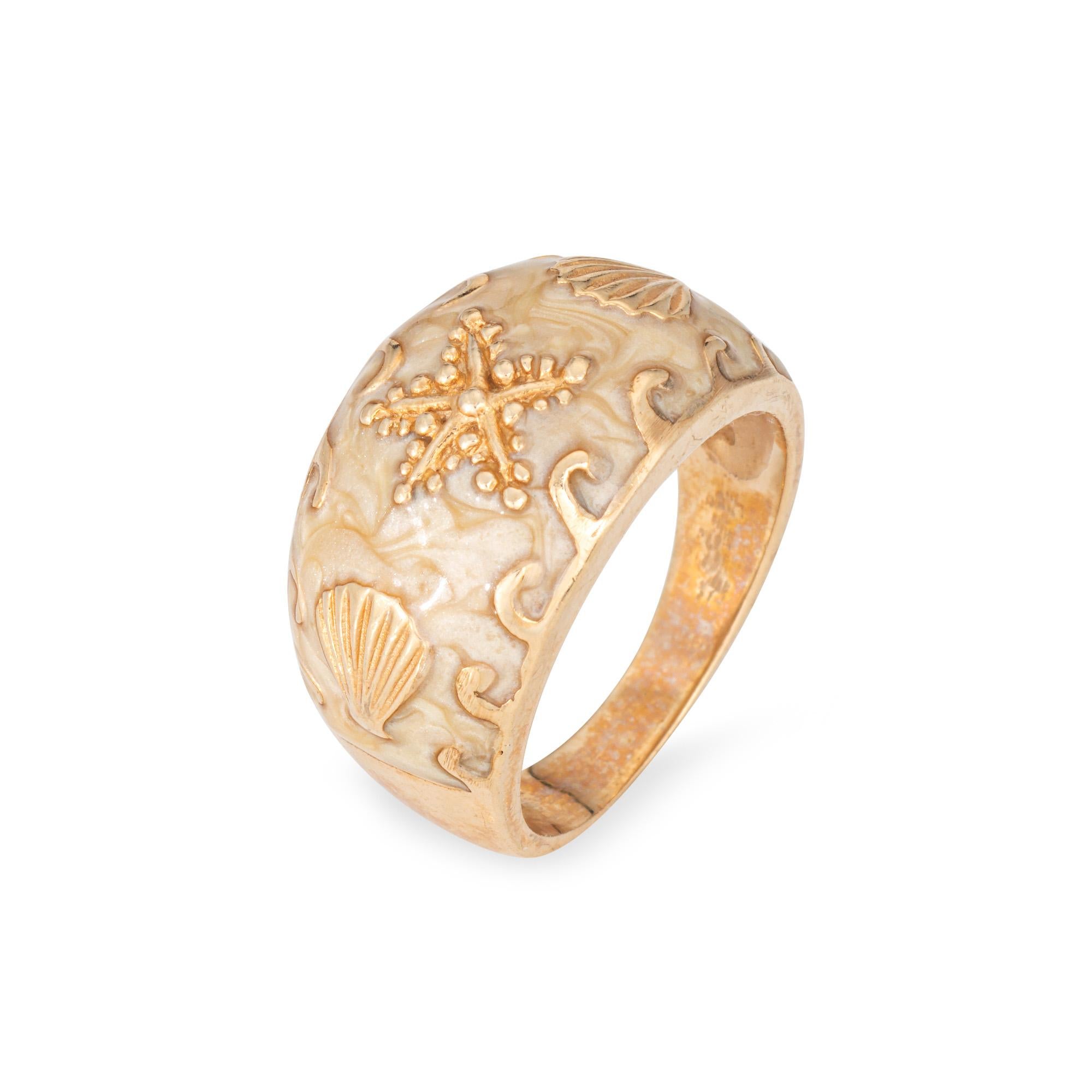 Finely detailed vintage conch shell ring crafted in 14k yellow gold (circa 1970s).  

A nod to the ocean and everything you love about the beach, the ring highlights a starfish to the center with two accenting sea shells. The ring is great worn