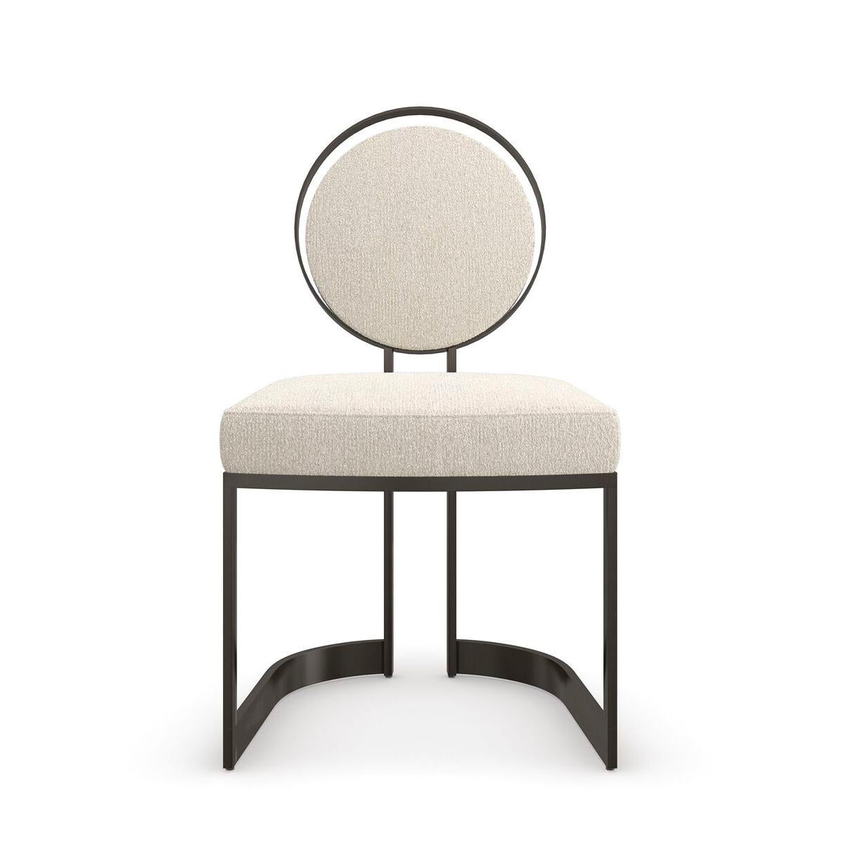 This sculptural metal chair lends an artful element to dining interiors, with a seemingly floating upholstered back set inside a metal circle. A sliver of space around the edges evokes phases of the moon and mimics its crescent-shaped frame. A
