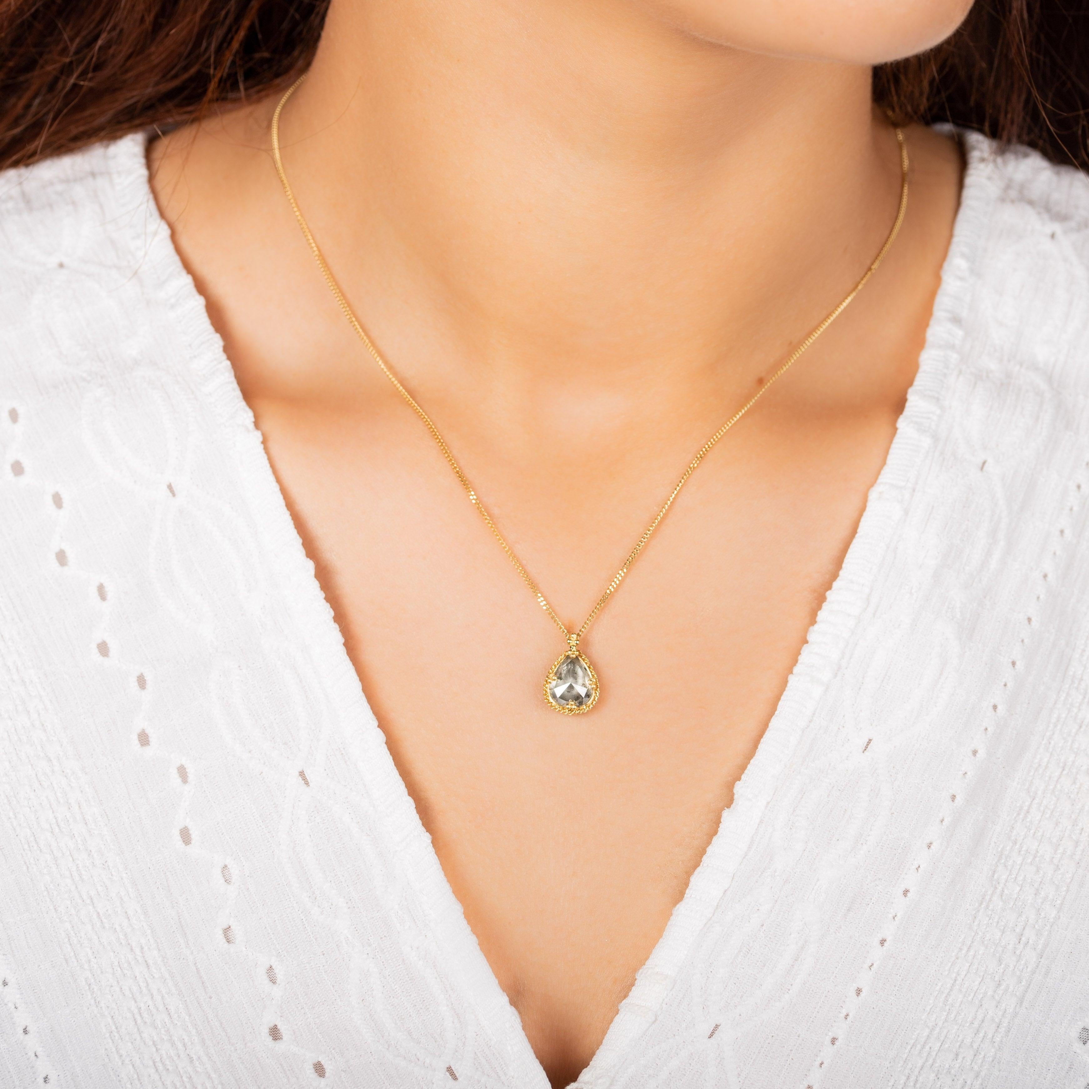 The lush facets of this delightfully chubby pear shaped Diamond glisten with a starlit subtlety, catching and reflecting light like the glittering, mysterious twinkle of celestial jewels in the night sky. Suspended from an 18K yellow gold chain,