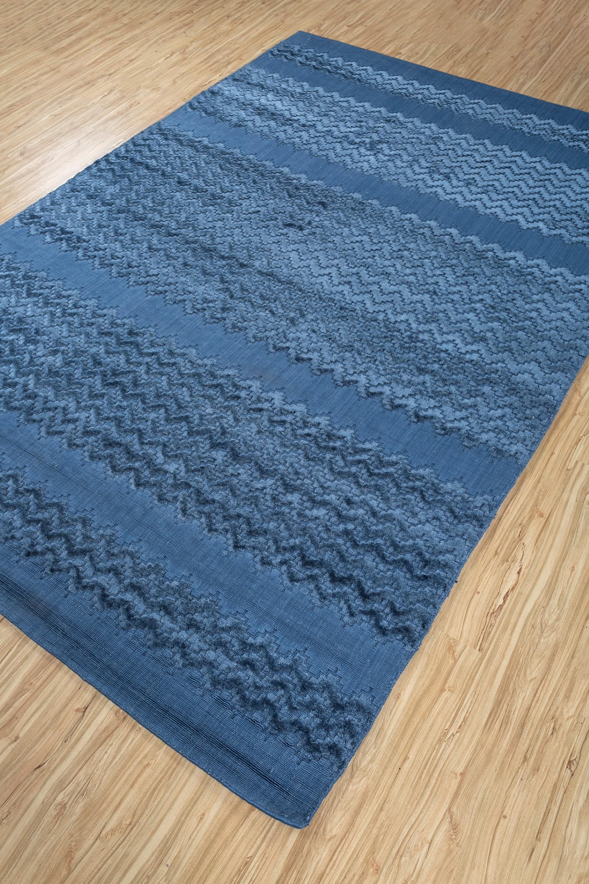 This hand loom piece from our Graze collection is a stunning example of contemporary elegance, seamlessly blending traditional craftsmanship with a modern aesthetic. This rectangular rug features a captivating design in a deep navy blue color,