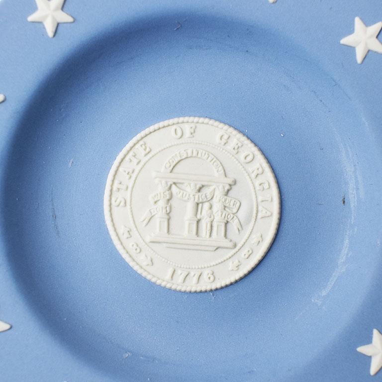 A beautiful collectible plate by Wedgwood. This is the perfect piece for the true southerner. This decorative plate or vide poche would make a fantastic catchall. The motif is dedicated to the state of Georgia. The center bears the State Seal in an