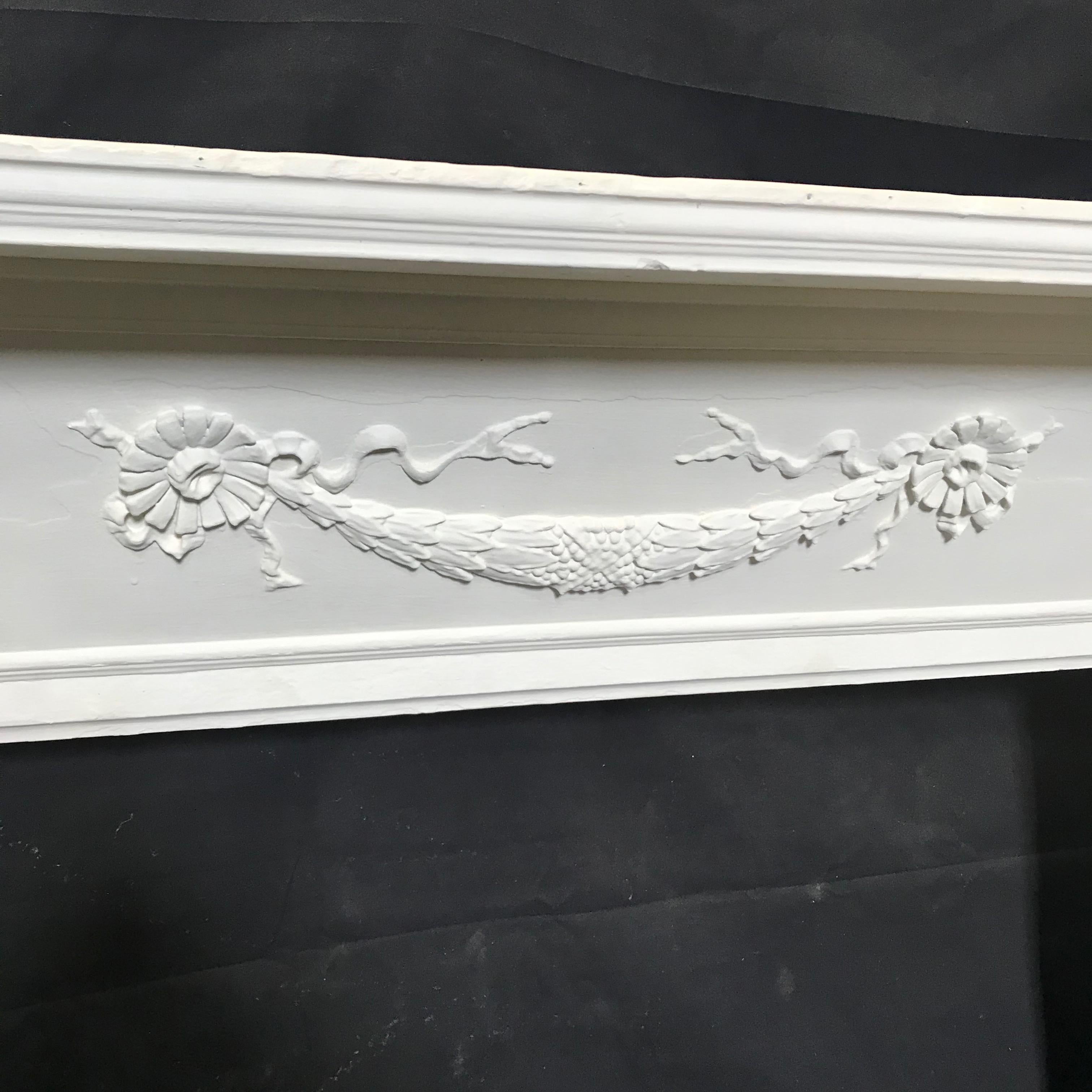 Beautiful wooden fireplace mantel with carved floral center swag and reeded federal columns - beautiful in front of the chimney.
Opening 28 H x 41.75 W
 #3686.