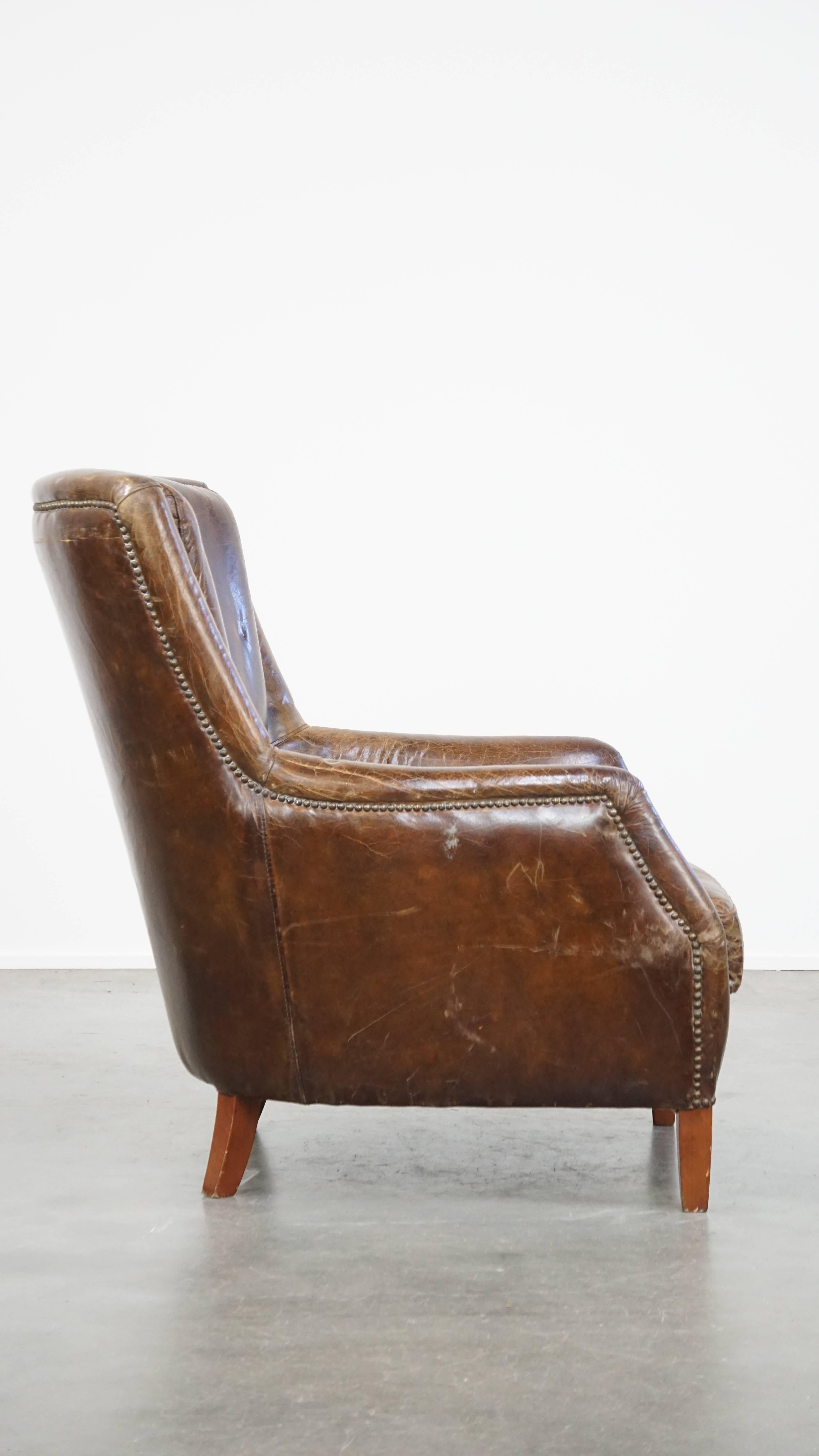 Hand-Crafted Stately and comfortable grained cowhide armchair with a timeless design For Sale