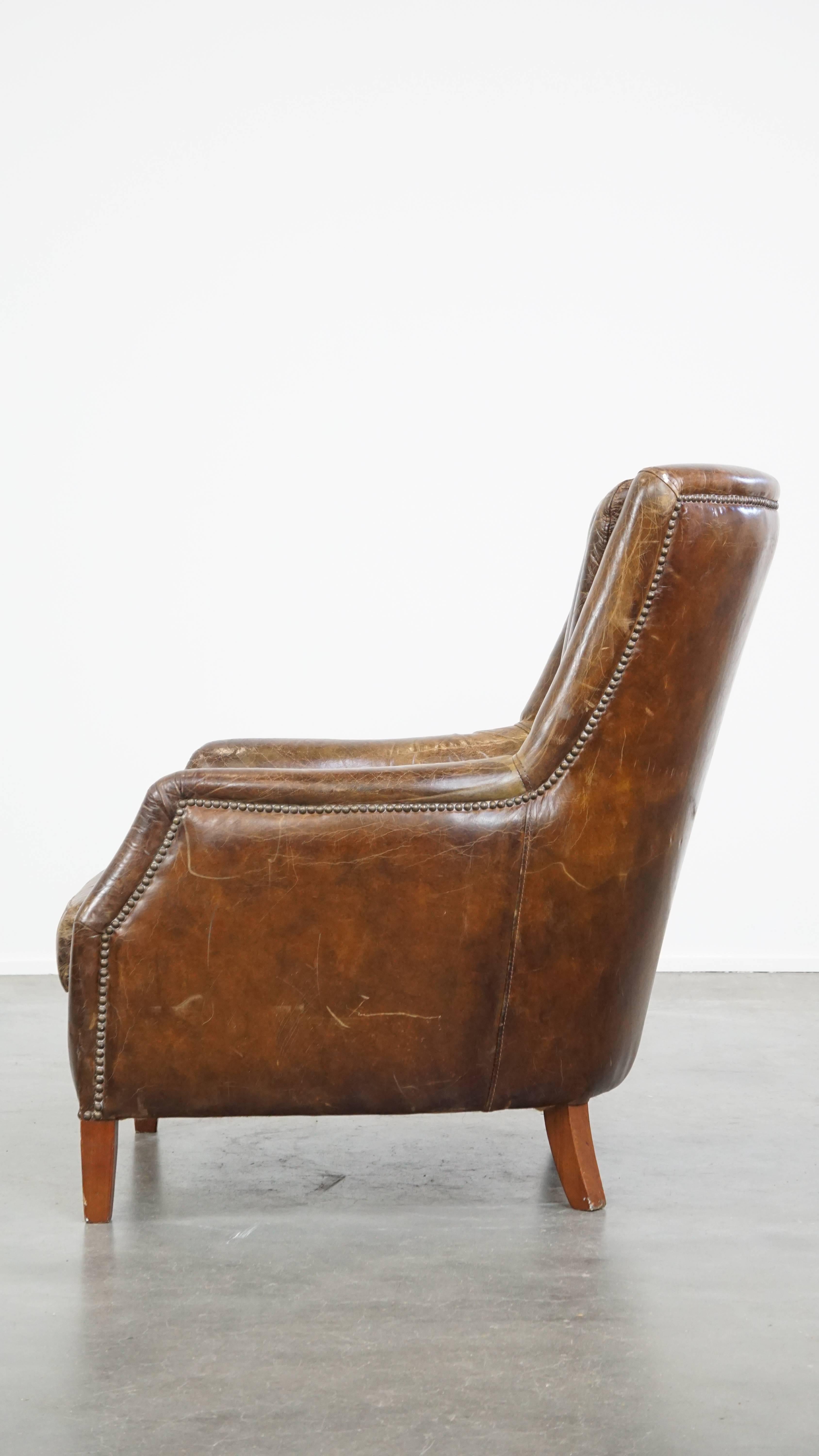 20th Century Stately and comfortable grained cowhide armchair with a timeless design For Sale