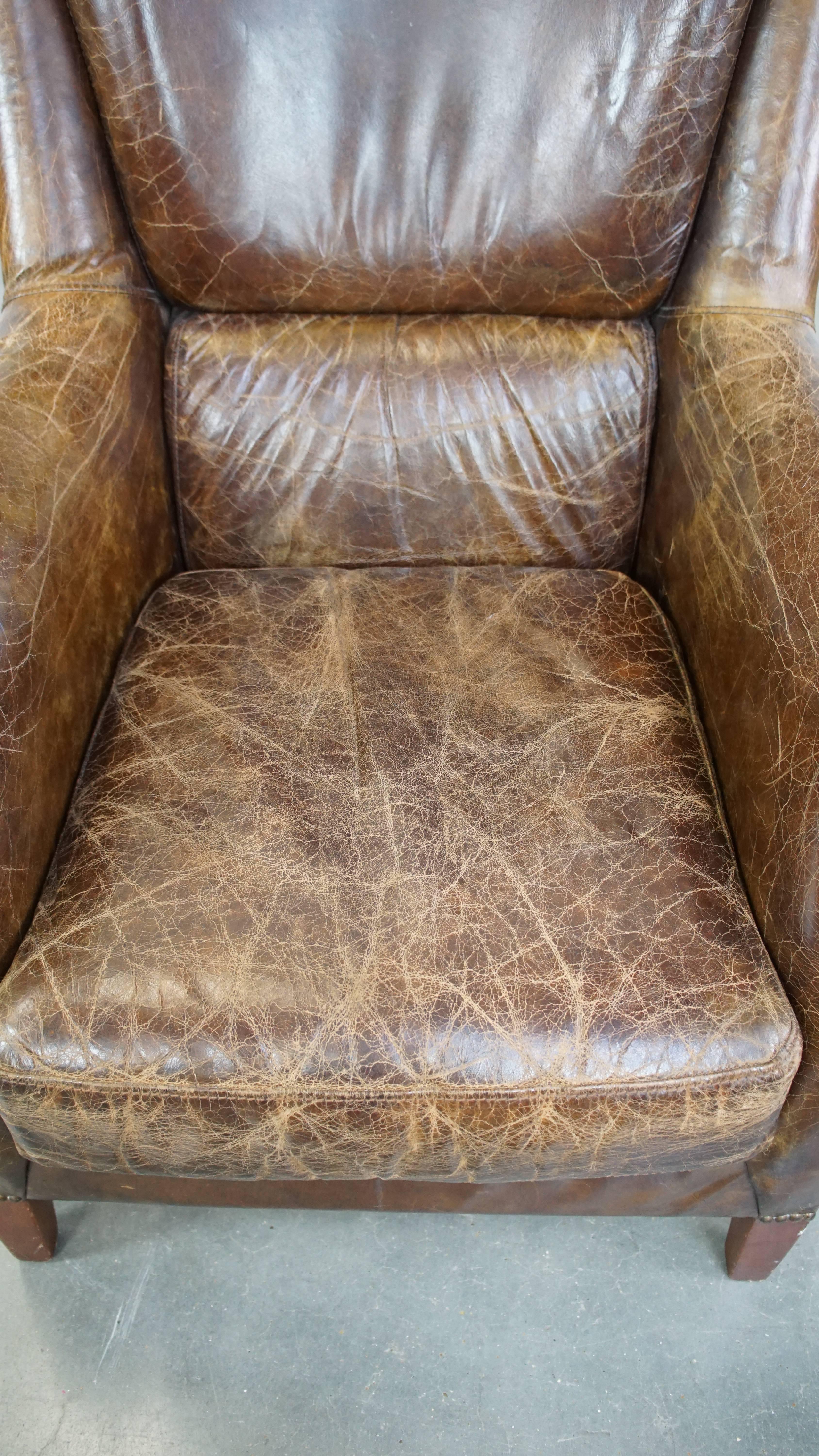 Cowhide Stately and comfortable grained cowhide armchair with a timeless design For Sale