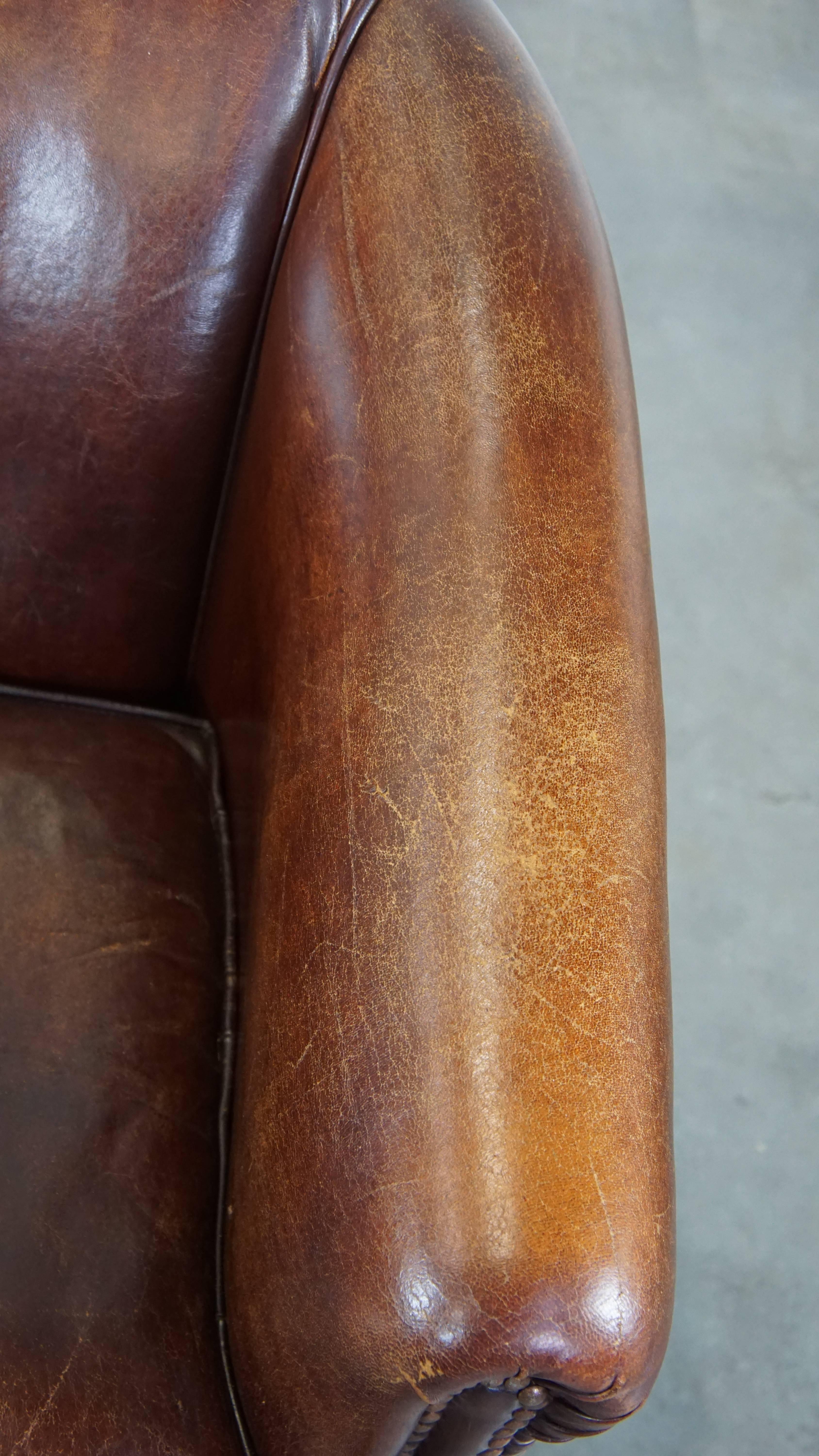 Stately, charming sheepskin club chair, correct finishing with decorative nails For Sale 1