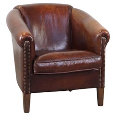 Fauteuil club majestueux en peau de mouton, bonne finition avec clous décoratifs