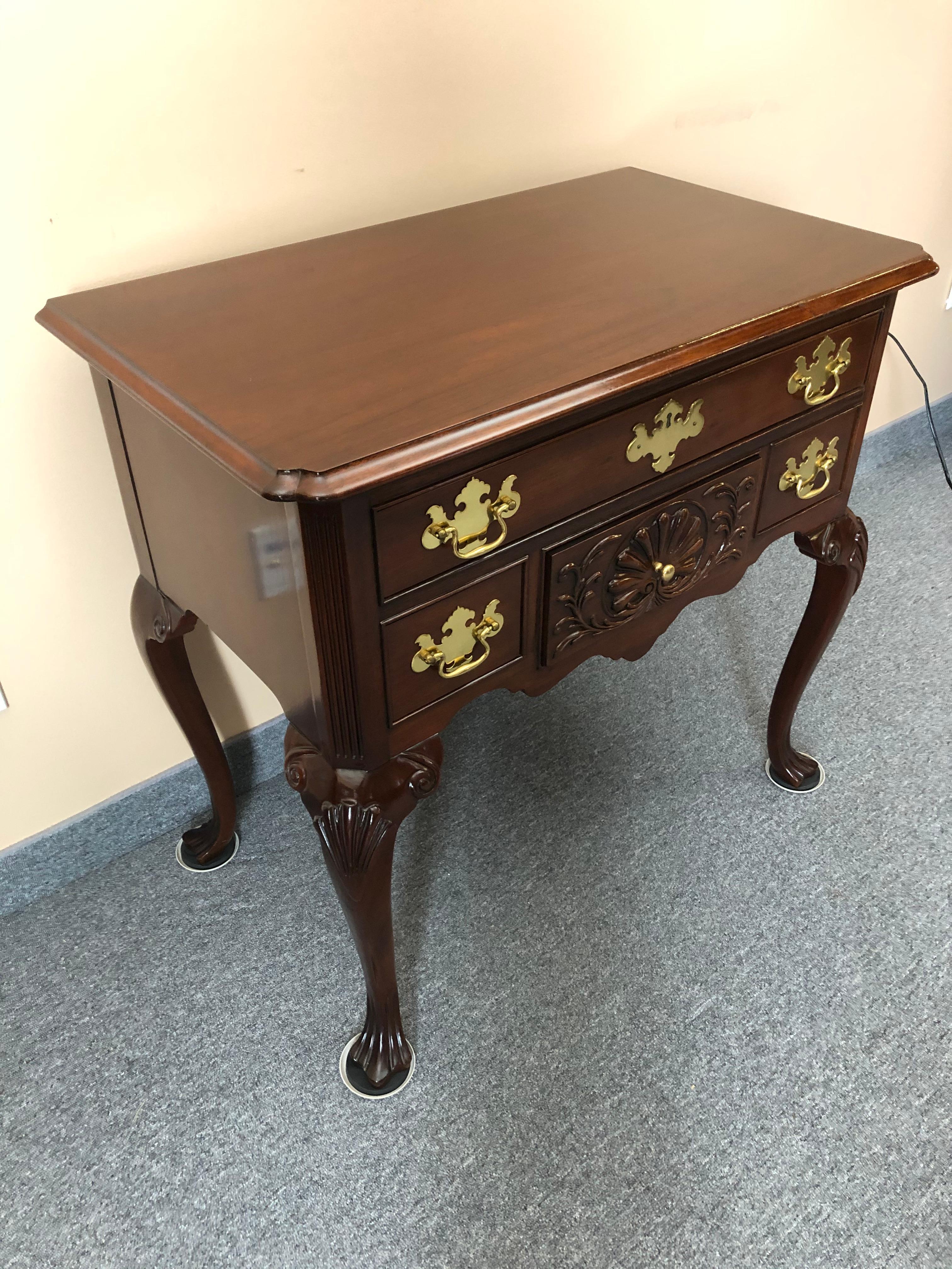 Stately Chippendale style lowboy having 3 drawers, cabriole legs with carved drape feet and classic brasses.