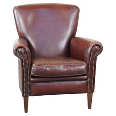 Stately, comfortable sheepskin armchair with proper finish and decorative nails