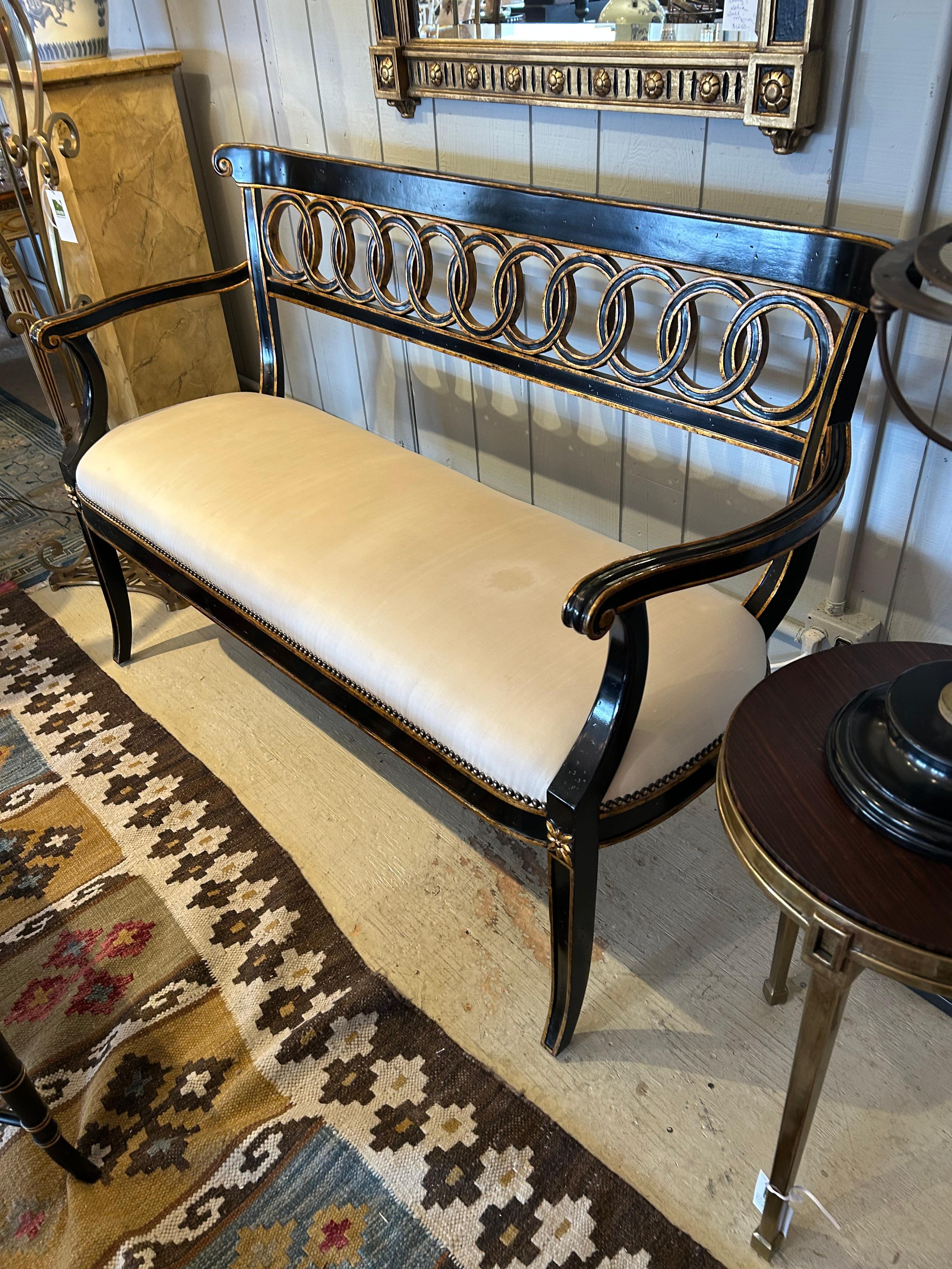 Magnifique causeuse Hollywood Regency noire et dorée avec motif de cercle sur le dossier et l'assise rembourrée.  Hauteur de l'accoudoir 28