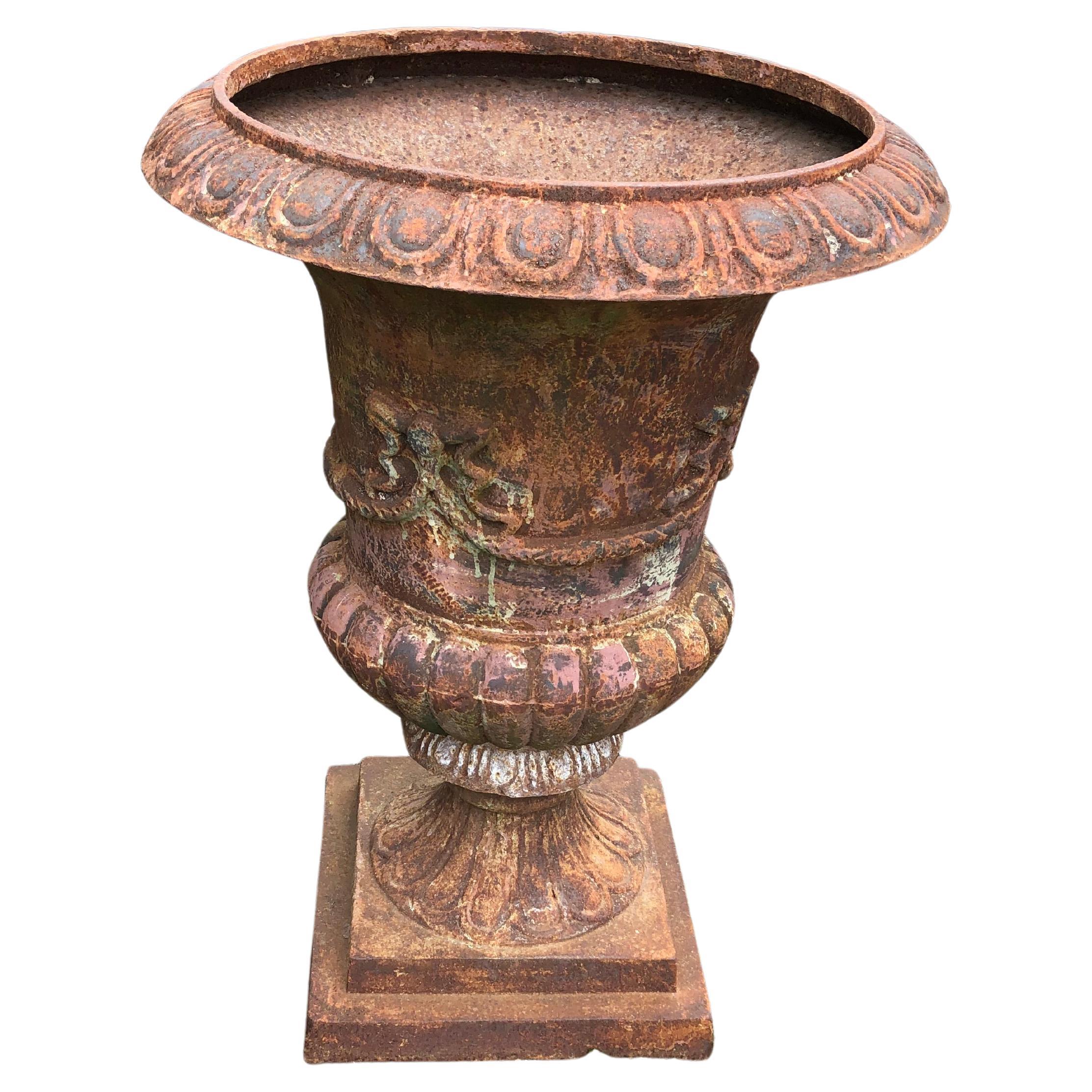 Stately neoclassical pair of large garden urn shaped planters having rust aged patina.