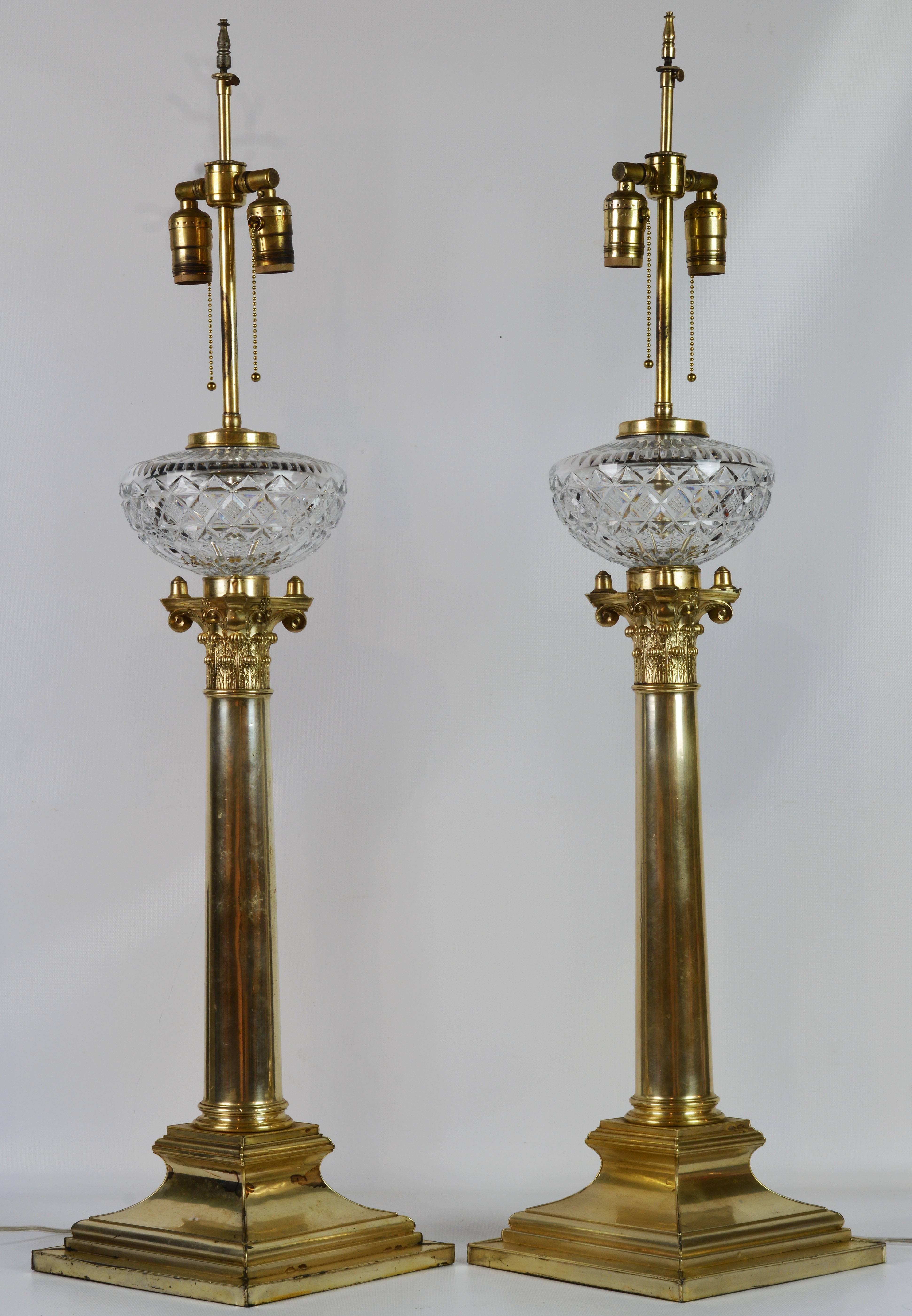 Standing 41 inches tall these impressive lamps were formerly oil lamps which have later been electrified retaining their magnificent cut crystal bowls. They are made of silvered brass in the Sheffield tradition and feature elegant Corinthian columns
