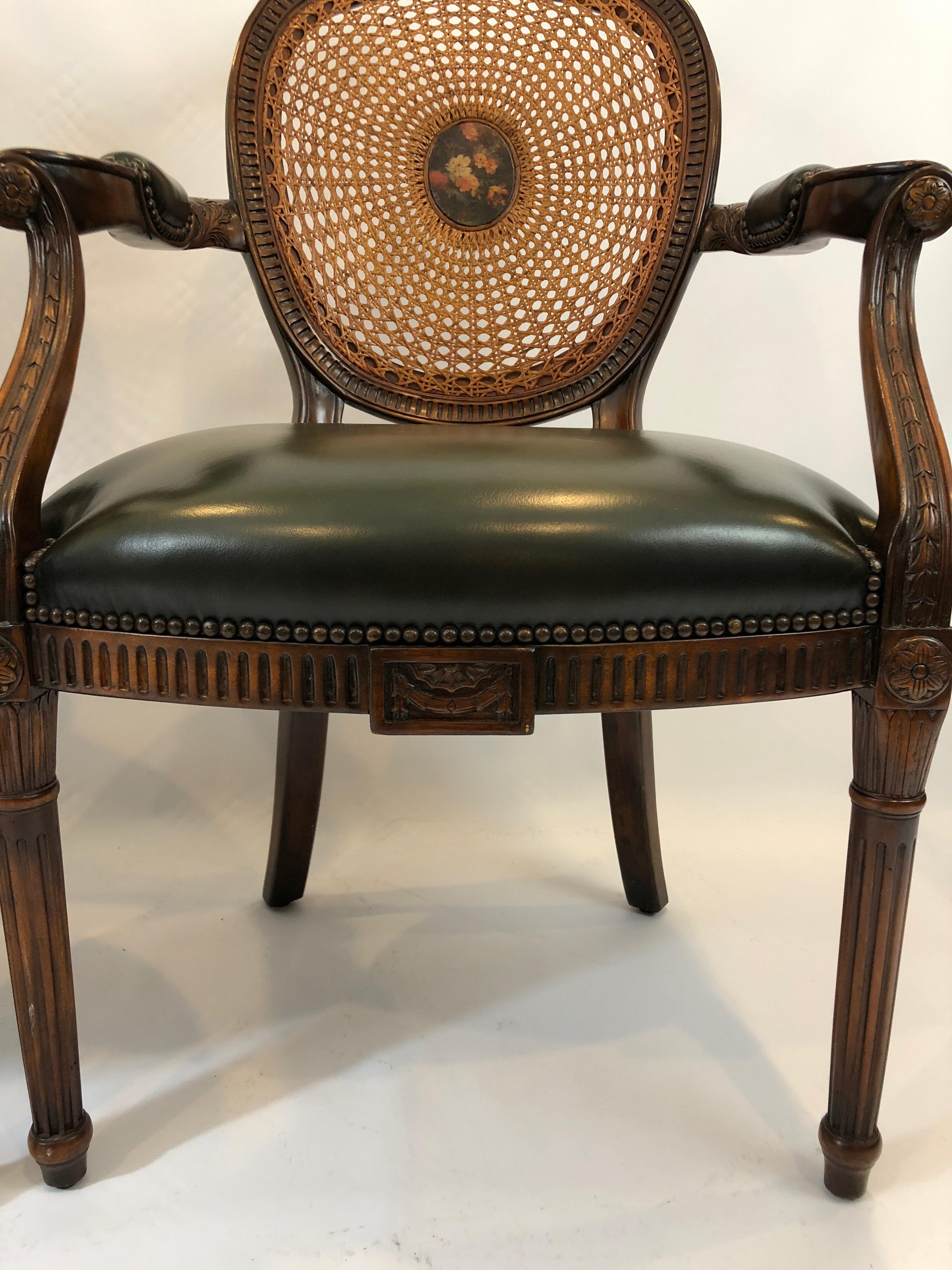 Stunning pair of ornately carved walnut armchairs having caned backs with center oval floral painted medallions and supple green leather seats.
Measures: arm height 28, seat depth 21.