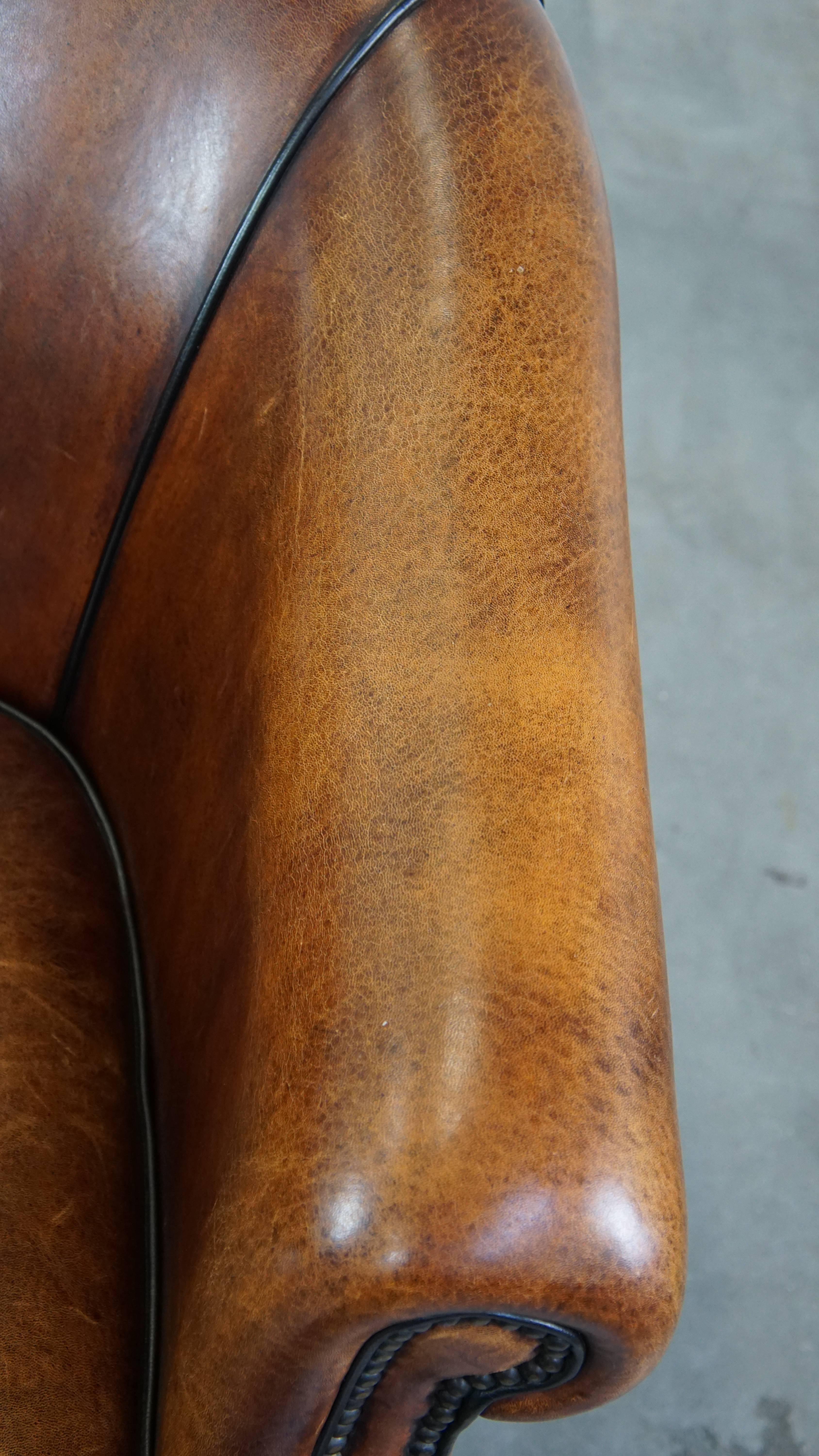 Majestuoso sillón club de piel de cordero acabado con clavos decorativos y ribete negro en venta 2