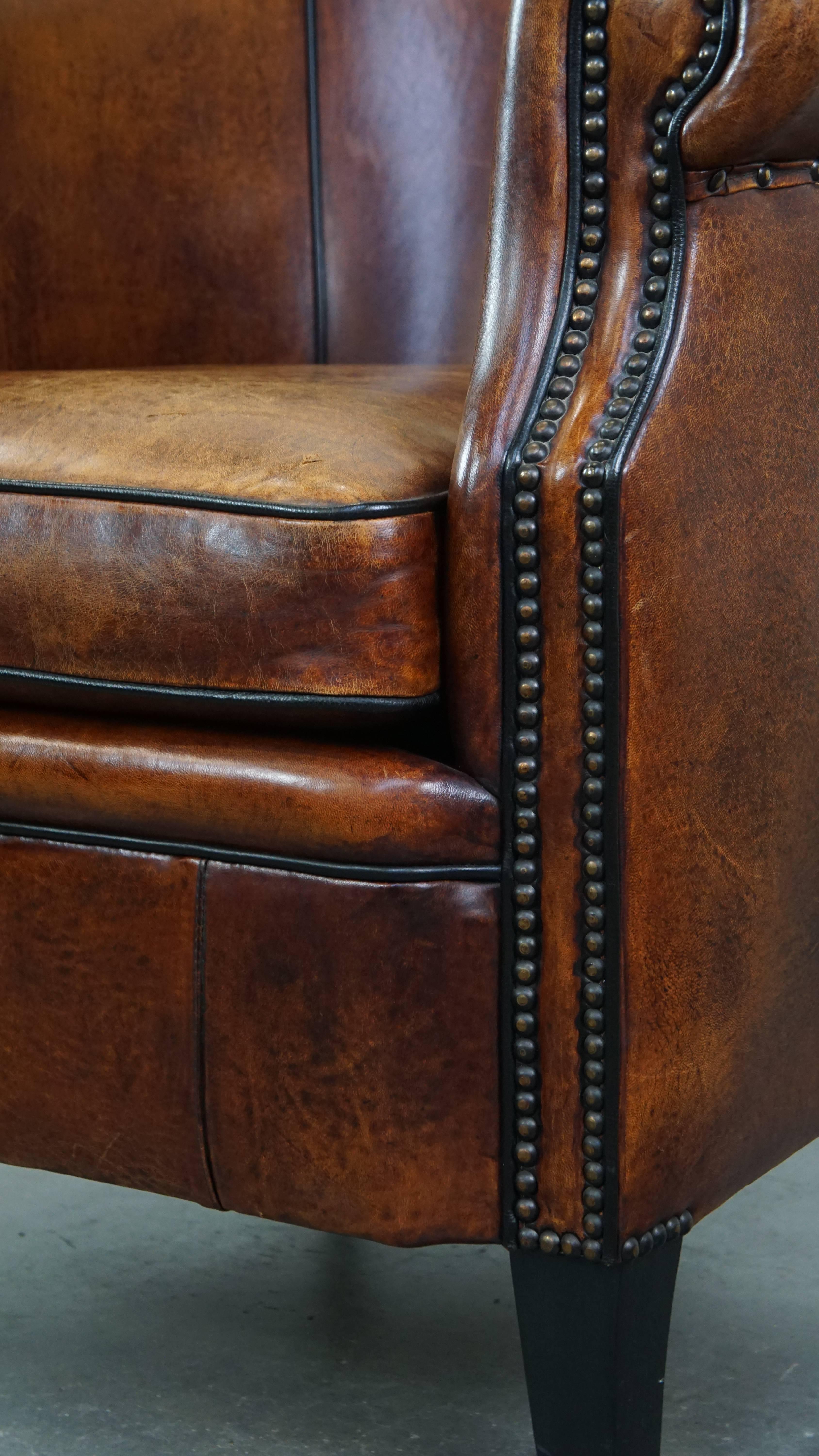Majestuoso sillón club de piel de cordero acabado con clavos decorativos y ribete negro en venta 3