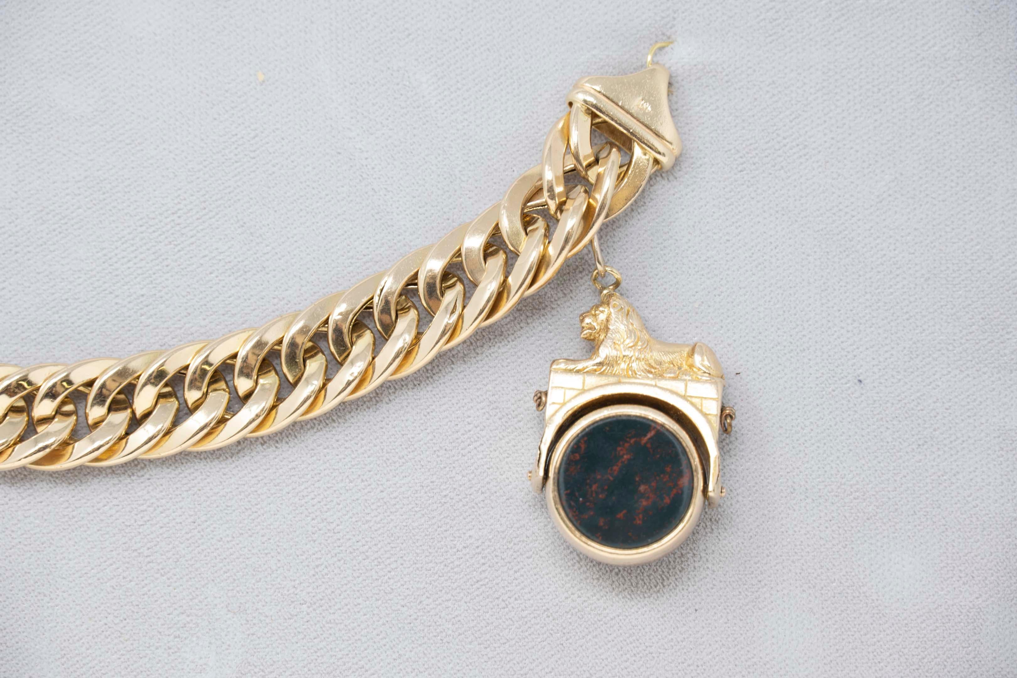 Statement 14k gold bracelet with bloodstone and conch shell spin FOB pendant. Early 20th century, the lion figural spinning FOB is probably earlier. Bracelet stamped 14k Italy, weighs 54.7 grams. Measures 7 1/2 inches long.
