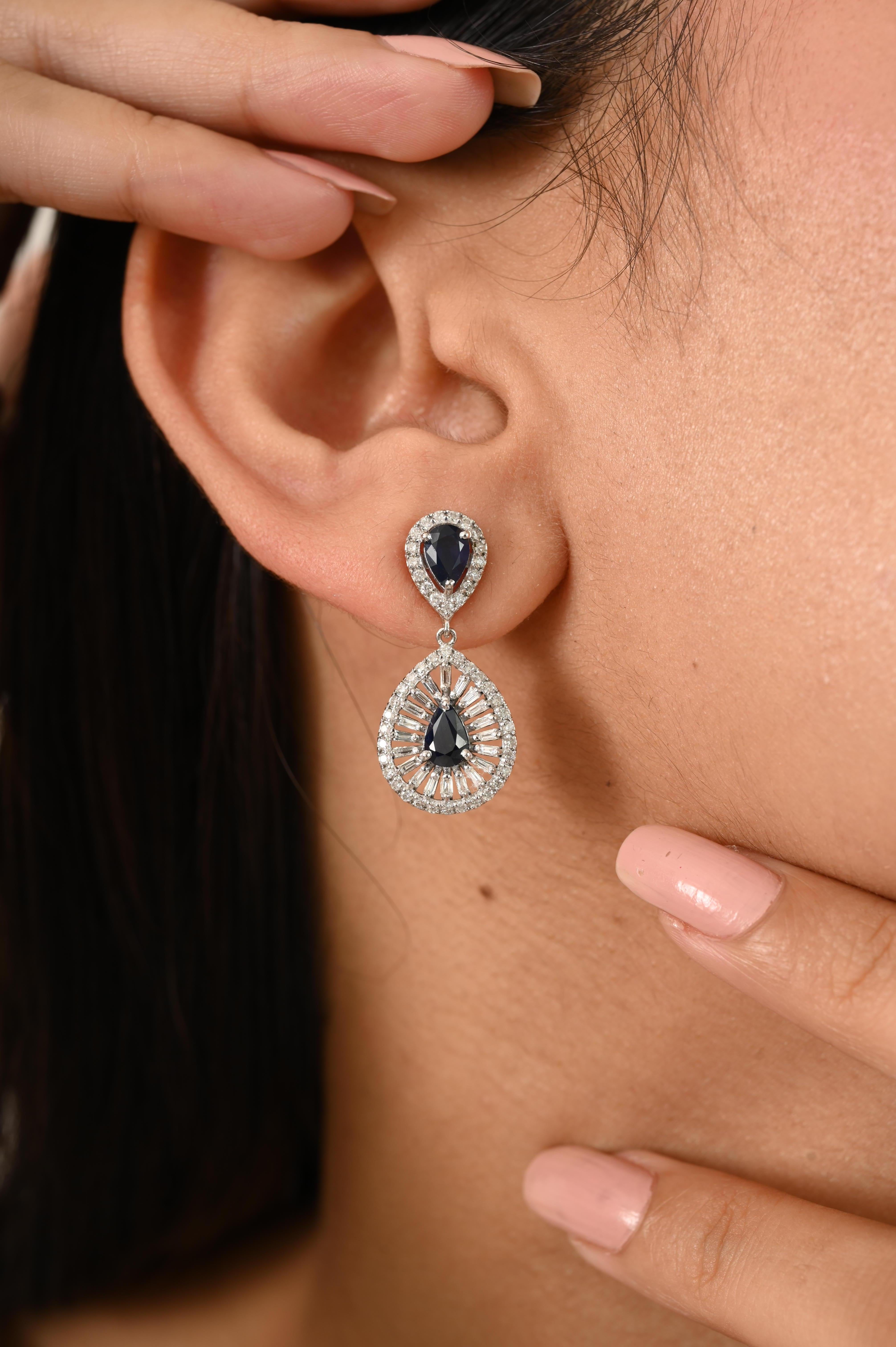 Ces boucles d'oreilles en or blanc 14k à halo de saphirs bleus taillés en poire et de diamants, fabriquées à la main en or blanc 14k luxueux, présentent un poids total de 1,90 carat de saphirs bleus taillés en poire, entourés de 1,01 carat de