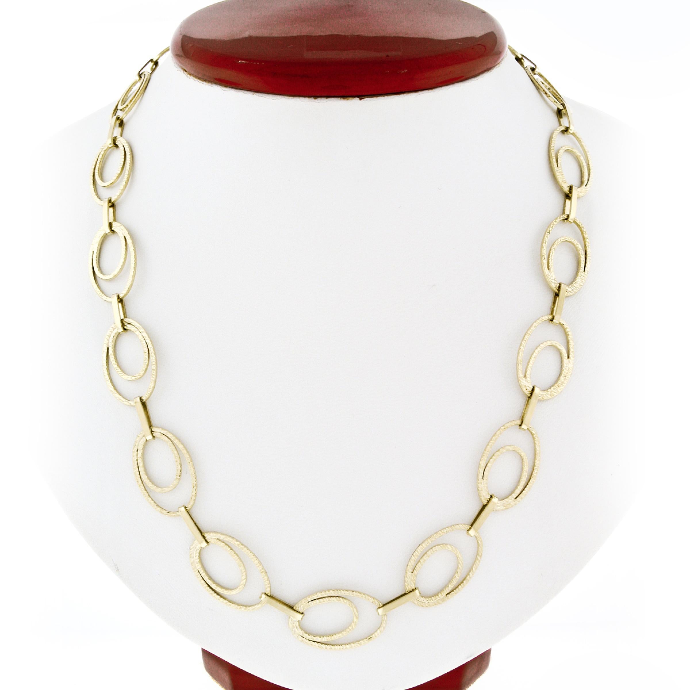 s statement 14k yellow gold necklace features open, dual oval links which elegantly interlock showing absolutely amazing texture throughout. The chain displays beautiful long look measuring 28 inches overall, and is secured with sturdy spring ring