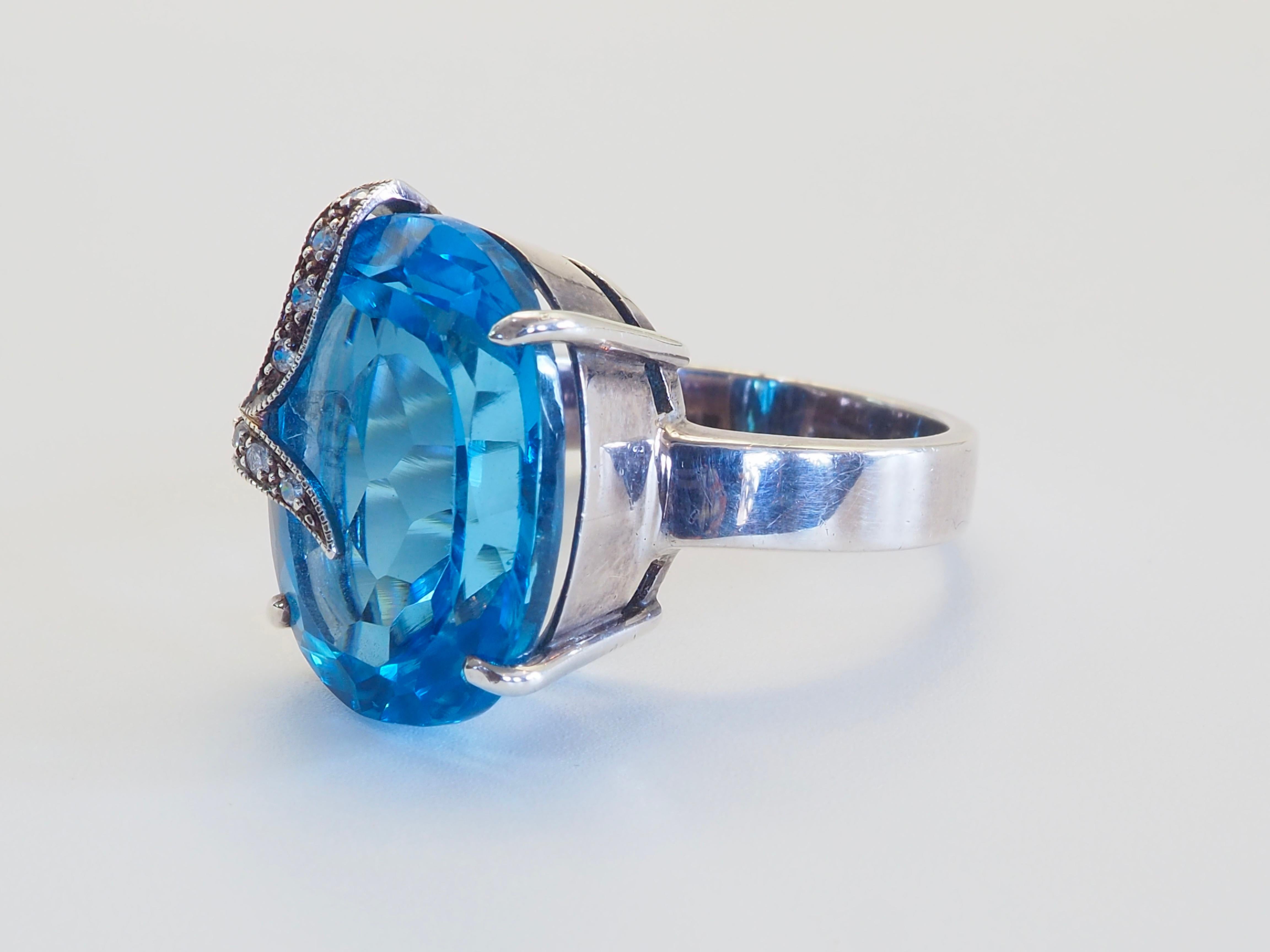 Un'accattivante fusione di brillantezza e maestria, questo raffinato anello presenta un Majestic topazio blu ovale da 17,09 carati, ricoperto da un luminoso quarzo bianco che ne esalta la profondità e lo splendore. La gemma è cullata con eleganza in