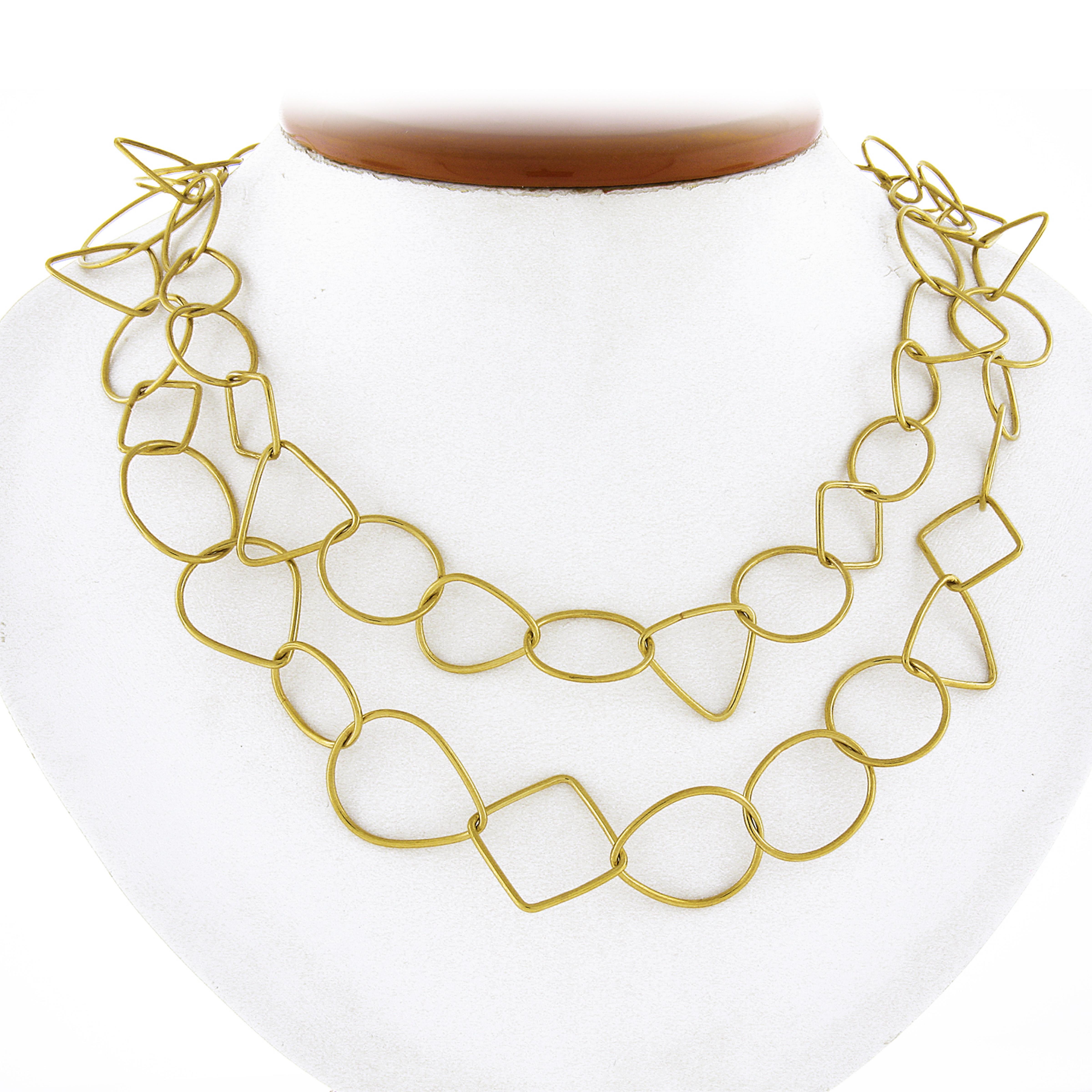 This statement 18k yellow gold necklace features open, geometric shaped wire links which elegantly interlocking showing absolutely luscious look throughout. The chain displays beautiful long look measuring 36 inches overall, and is secured with hook