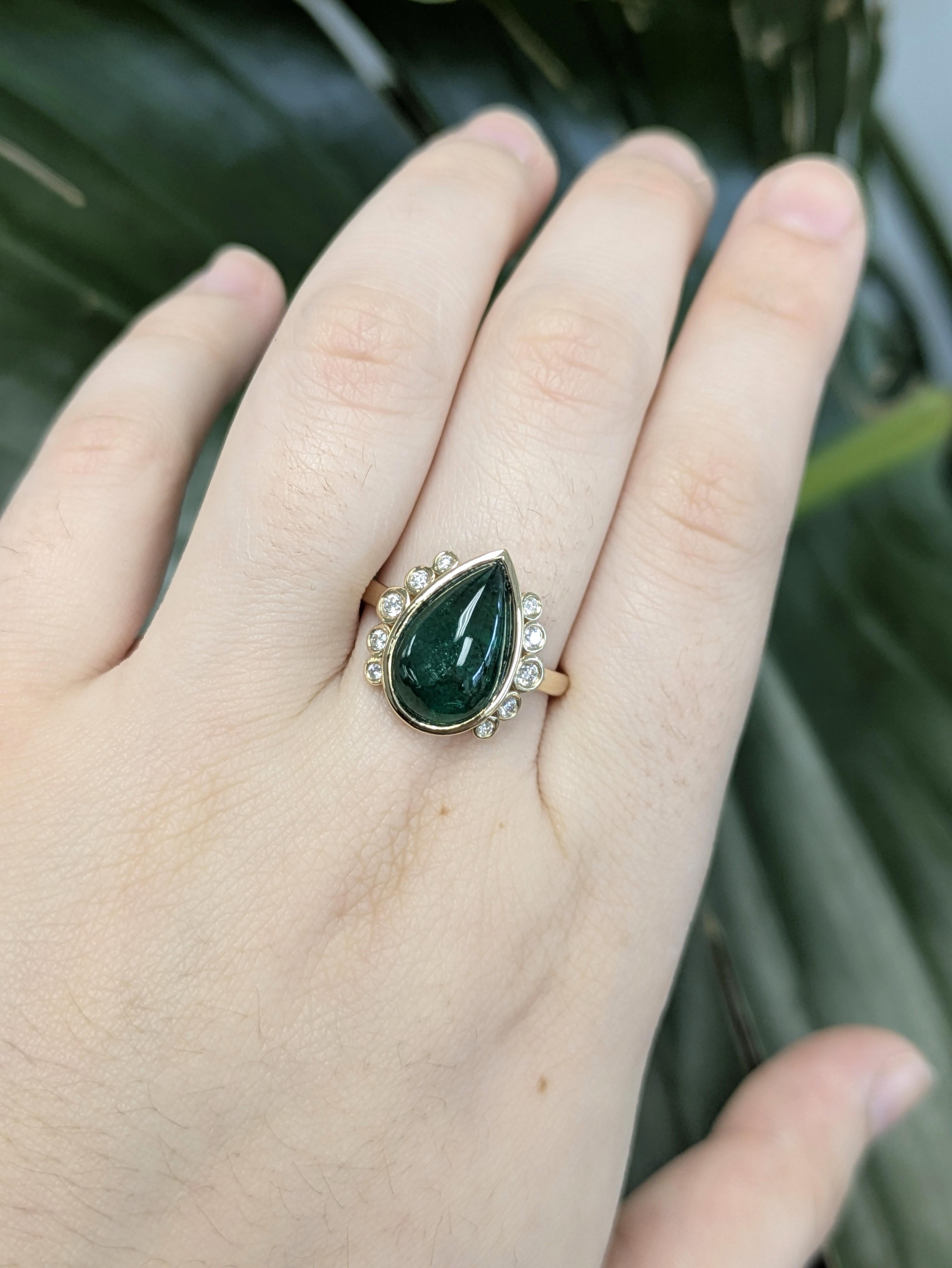 Superbe bague en or 14k mettant en valeur une émeraude zambienne en forme de poire de 5,09 carats (14,2x8,9 mm), rehaussée d'un traitement traditionnel à l'huile afin d'enrichir sa teinte verte éclatante. Accentuée par 10 diamants brillants
