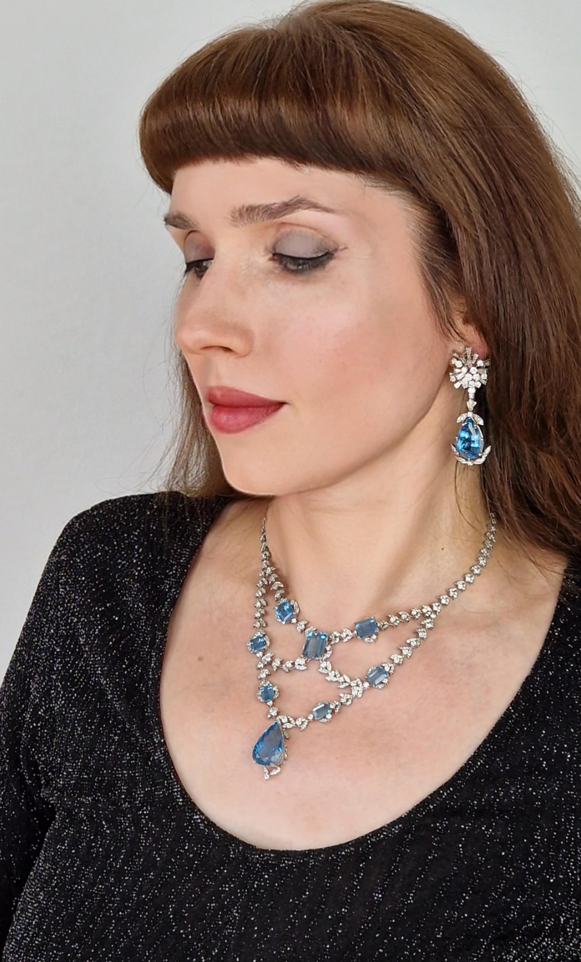 This wonderful pair of earrings features two perfectly matched dark blue aquamarine pear drops suspended from large sunburst clusters of brilliant and tapered baguette diamonds.

The length of the earrings is 6.7cms and they have a post and