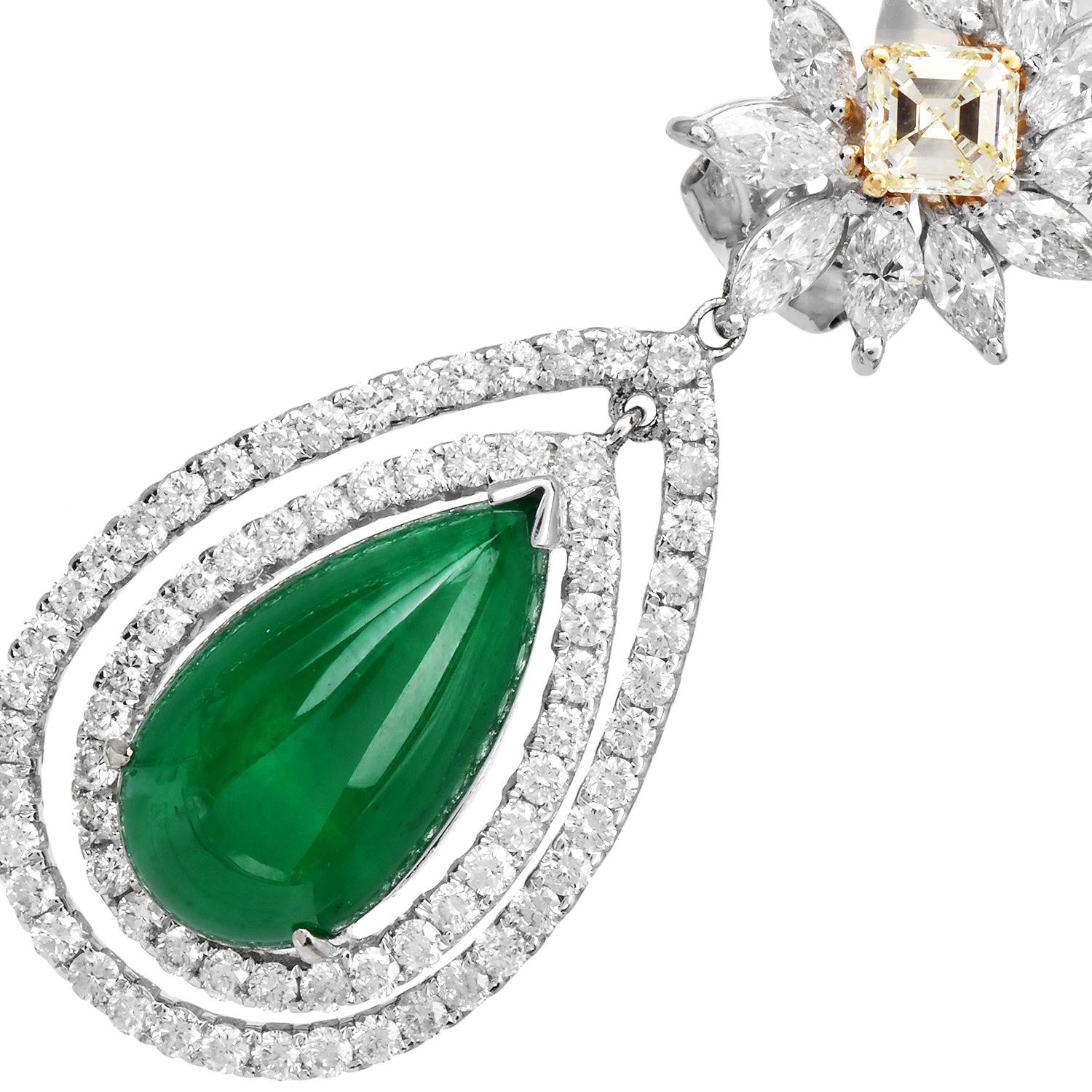 Elegant statement drop earrings, these 18K gold bridal cocktail earrings feature pear-shaped Genuine vivid Green emerald cabochon framed by a double halo of brilliant round diamonds. The floral stud design is centered with two asscher-cut light