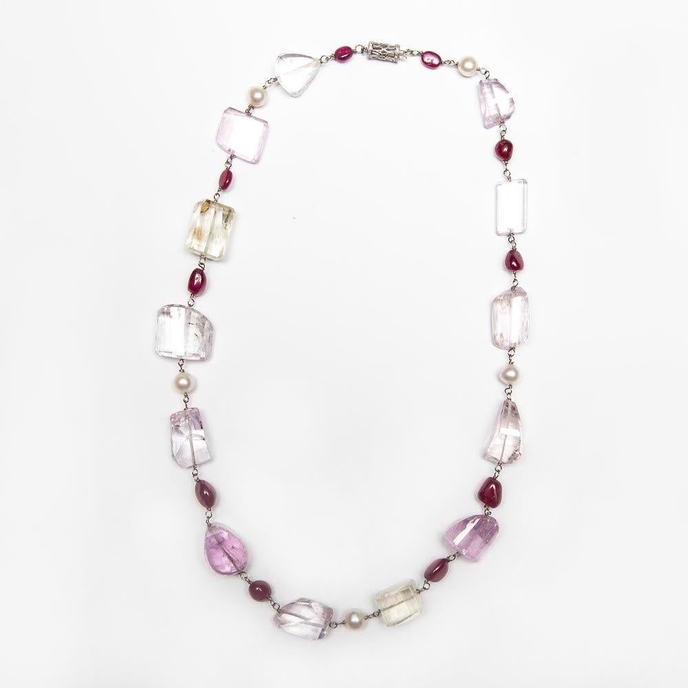 This necklace features Pink Kunzite, Tumbled Ruby Beads, and Fresh Water Cultured Pearls that are Hand Wire Wrapped in 14kt White Gold. It measures 22 Inches and can be worn over a Sweater or Shirts as well as with dresses. The Clasp is in a