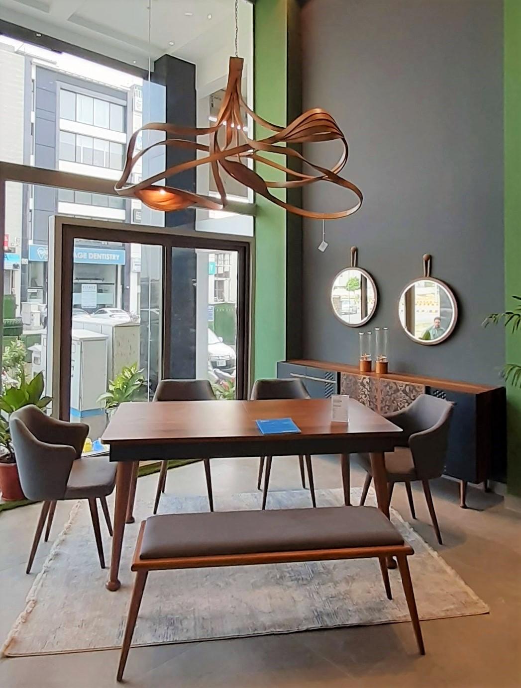 A chandelier made in solid ashwood using wood bending techniques. The piece is a complex design, giving it a varying look from each angle. Three-light are placed in a wooden cocoon-like structure creating a distinct lighting ambiance. The natural