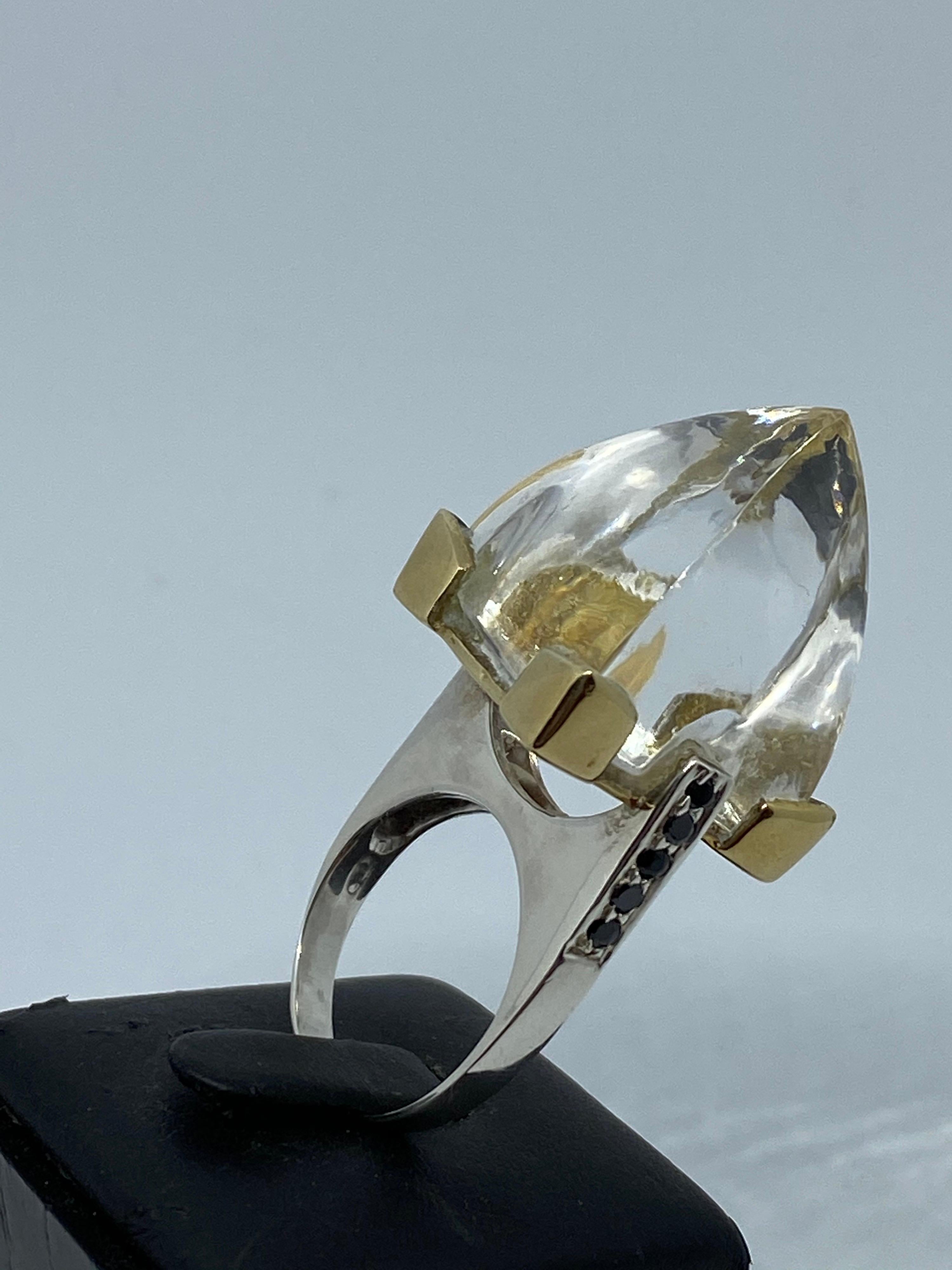 Make a statement with this pointy unique ring. Measures 2 inches and 3/4 in length and has a large pointed Sugarloaf Quartz Crystal set with 10 round black onyx gemstones and Gold plated prongs holding the Crystal in place, the whole ring is in
