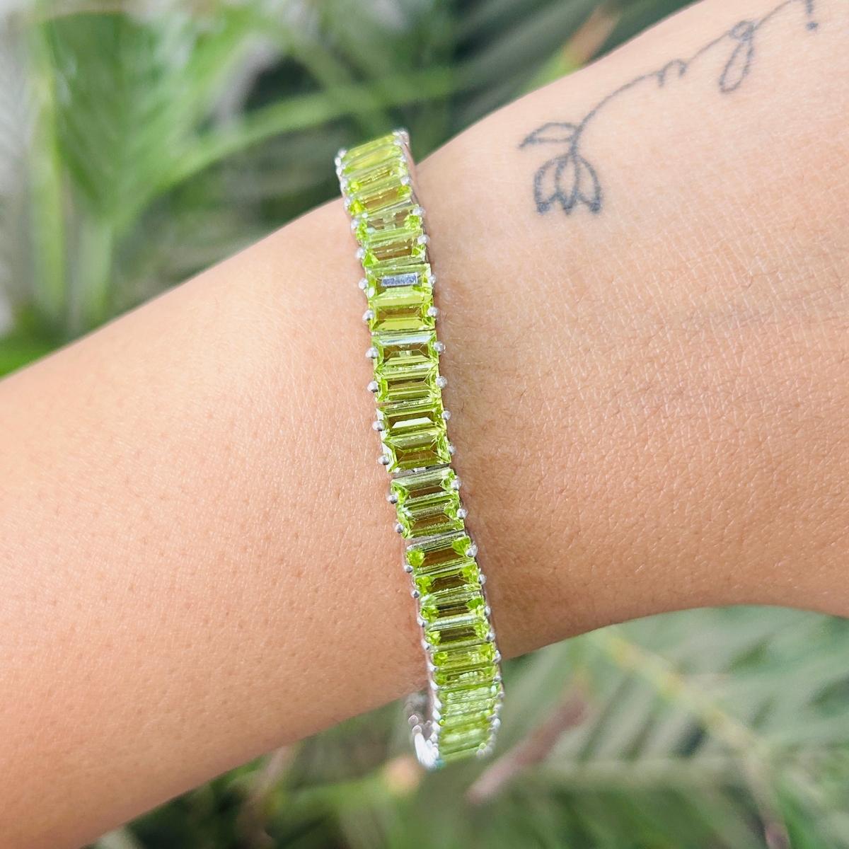 Il bracciale tennis Statement Natural Peridot in argento sterling mette in mostra uno scintillante peridoto naturale del peso di 19,45 carati. Misura 7.25 pollici di lunghezza. 
Il peridoto stimola la concentrazione e riduce lo stress. 
Progettato