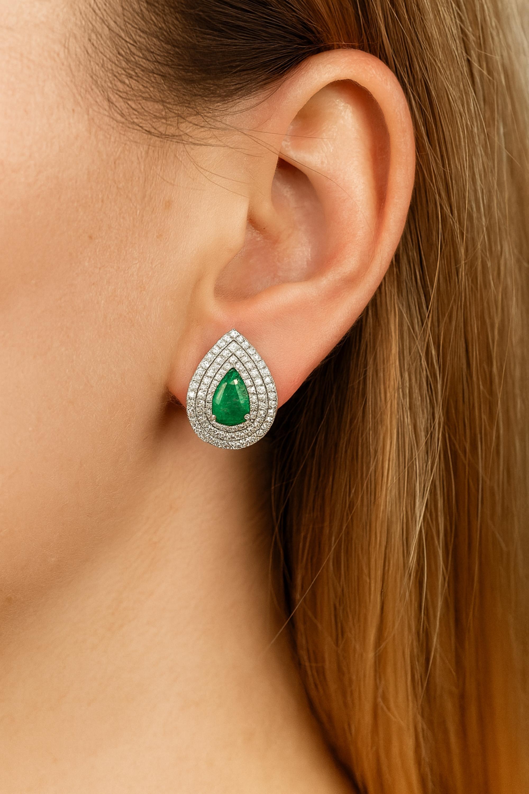 Boucles d'oreilles en or blanc 18k avec émeraude et diamant en forme de poire et triple halo  Ces boucles d'oreilles sont ornées d'une émeraude classique en forme de poire. Chaque émeraude est entourée de multiples halos graduels de diamants ronds