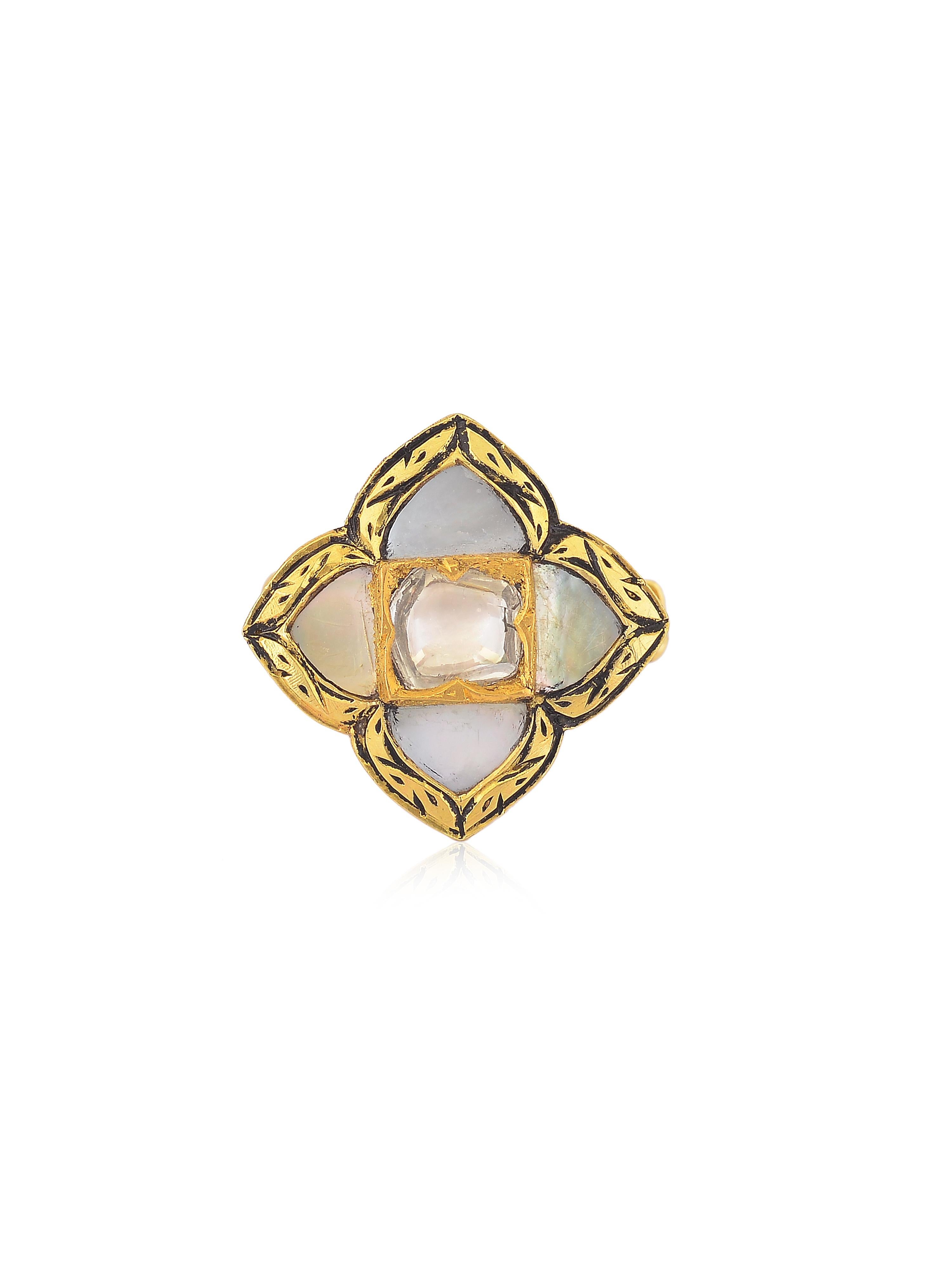 A statement ring with Mother of Pearl and a shiny uncut diamond in the centre. You will notice black enamel work all around the border of the ring, this work is called 