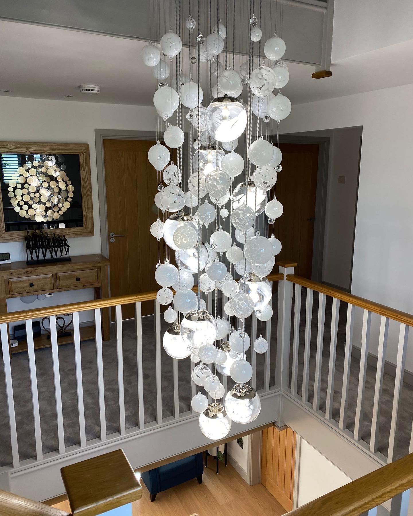 This contemporary chandelier is a Cascade design and features individually blown glass spheres. The glass is blown in Europe and the UK and the chandelier is designed and hand-crafted in our studio in South London. 

This chandelier is 55/60cms