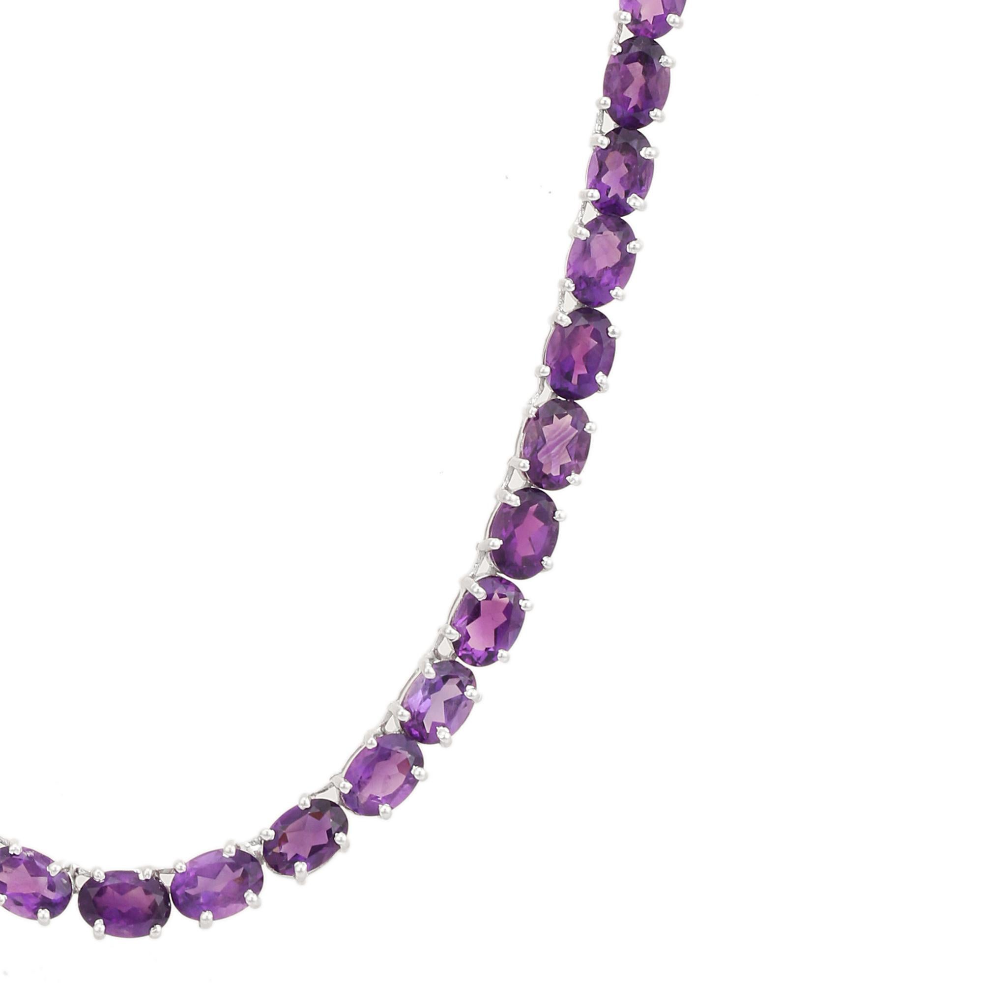 Questa collana da tennis con gemme ovali di ametista è un gioiello di lusso da regalare con un filo continuo di gemme ovali di ametista, riccamente saturate, incastonate a mano nell'argento 925. Le profonde sfumature viola brillano con intensità,