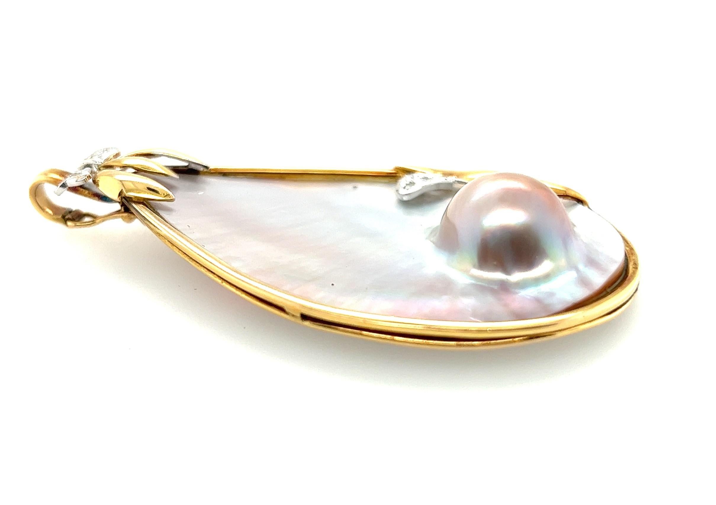 14kt yellow gold pendant containing one statement sized blister pearl with diamonds. 

The pendant measures 2 7/8 inches long by 1 5/8' at the widest point. 

 The bow designed yellow gold frame contains .11 carats of diamonds. The diamond appear to