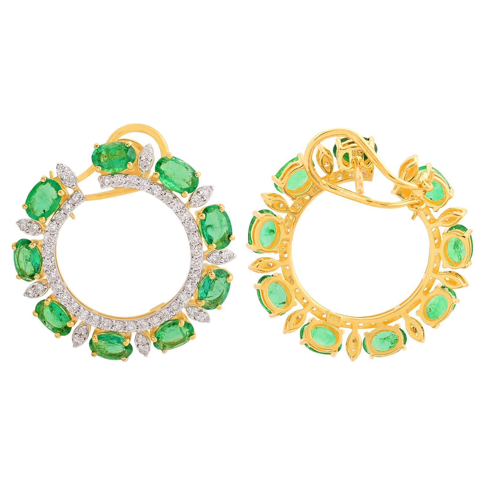 Ces boucles d'oreilles en or jaune 14 carats sont composées d'émeraudes de taille ovale serties de diamants en forme de cercle, ce qui en fait de grandes boucles d'oreilles.
Les émeraudes sont des symboles d'amour, de renaissance et de prospérité.