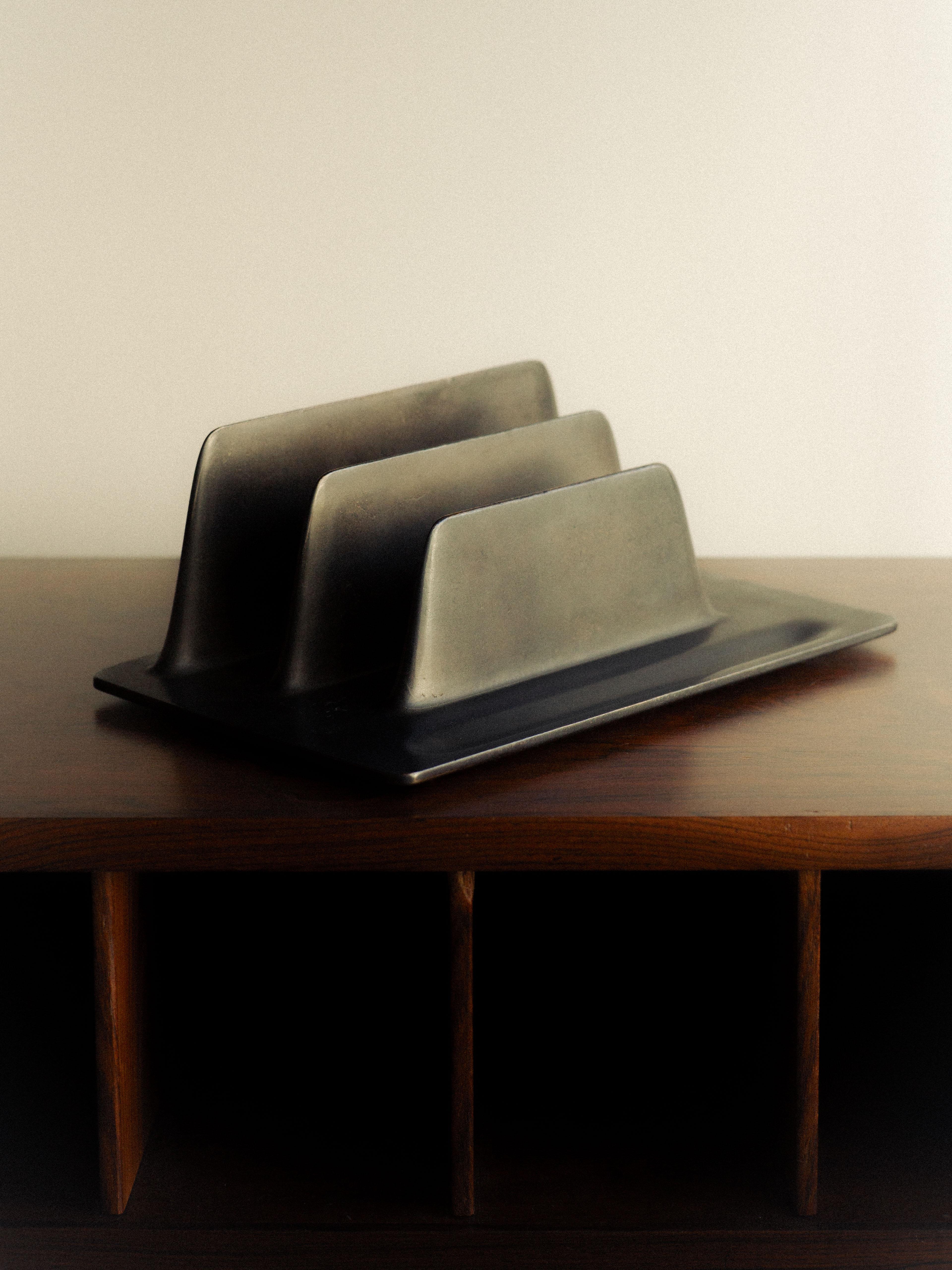 Stationery Patinated Bronze Card Holder by Henry Wilson
Dimensions: W 14,7 x D 22,5 x H 8,3 cm.
Materials: Bronze.

Bronze Stationery Holder is an object of fluid, futuristic form instigated and perfected in the virtual world, then rendered