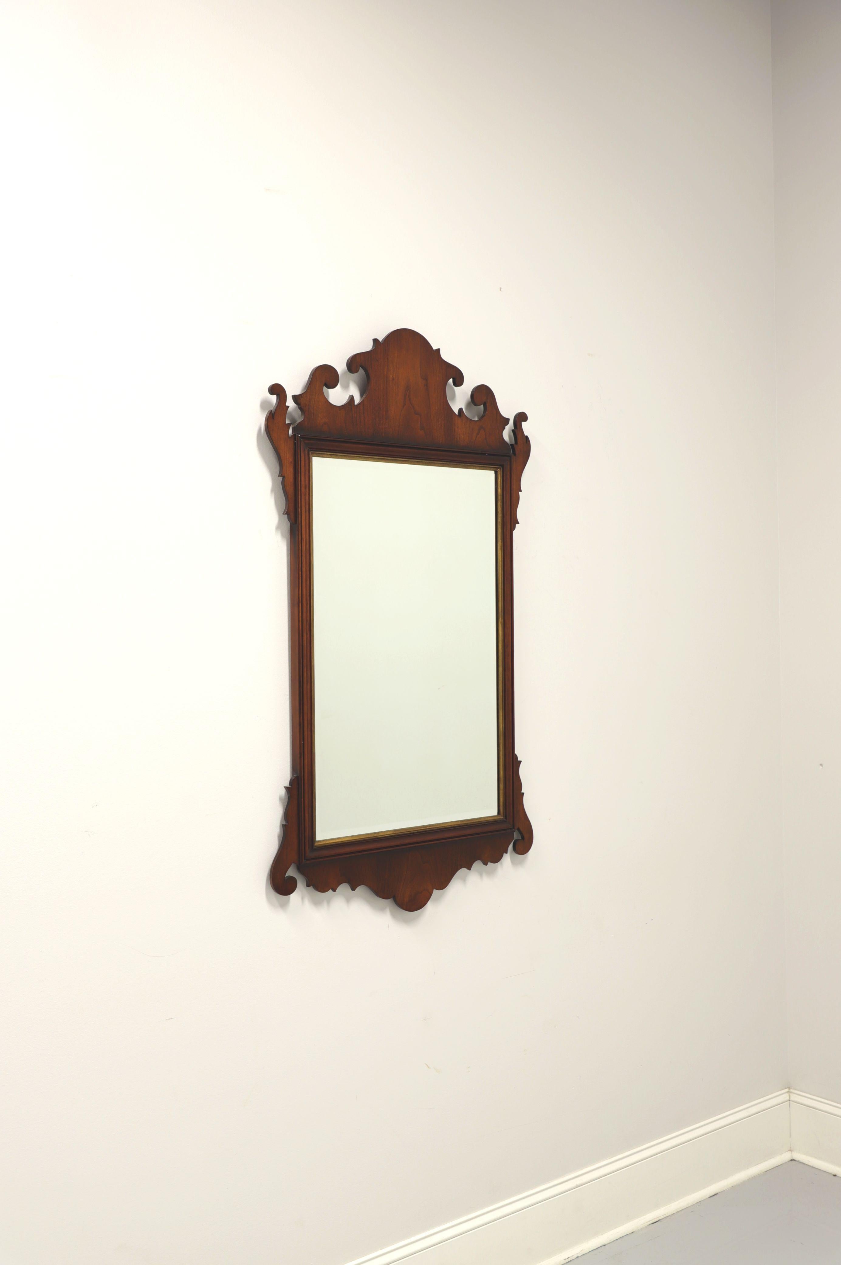 A Chippendale style wall mirror by Statton, with their Centennial finish to frame. Mirror glass, cherry wood frame with gold trim, decorative carving to top and bottom. Made in the USA, circa 1982.

Style #:  1422

Measures: 28.25W 1.25D 49.25H,