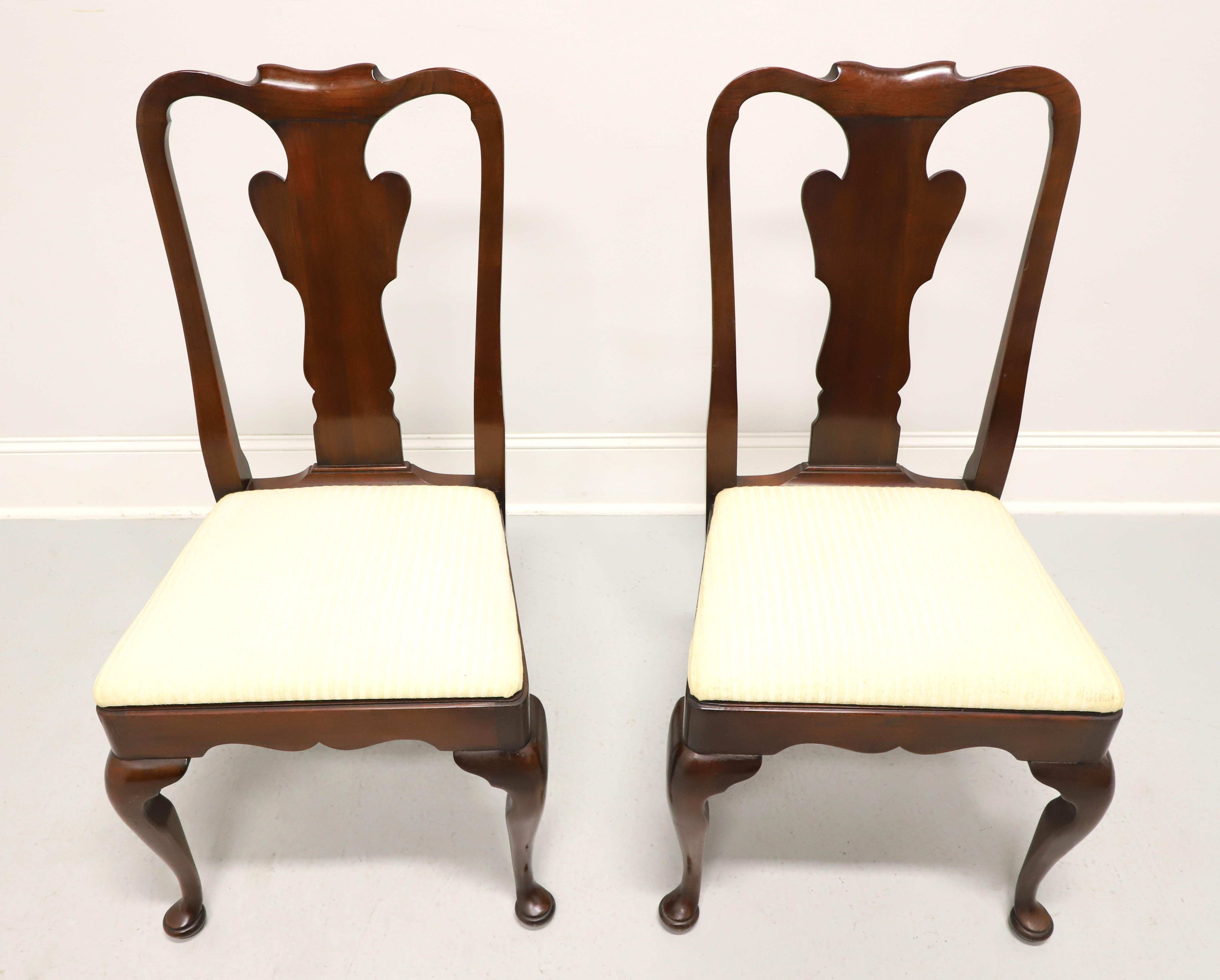A pair of Queen Anne style dining side chairs by Statton Furniture. Solid cherry wood with their Old Towne finish, rounded crest rail, carved backrest & apron, neutral cream color textured fabric upholstered seat, cabriole legs, and pad feet. Made