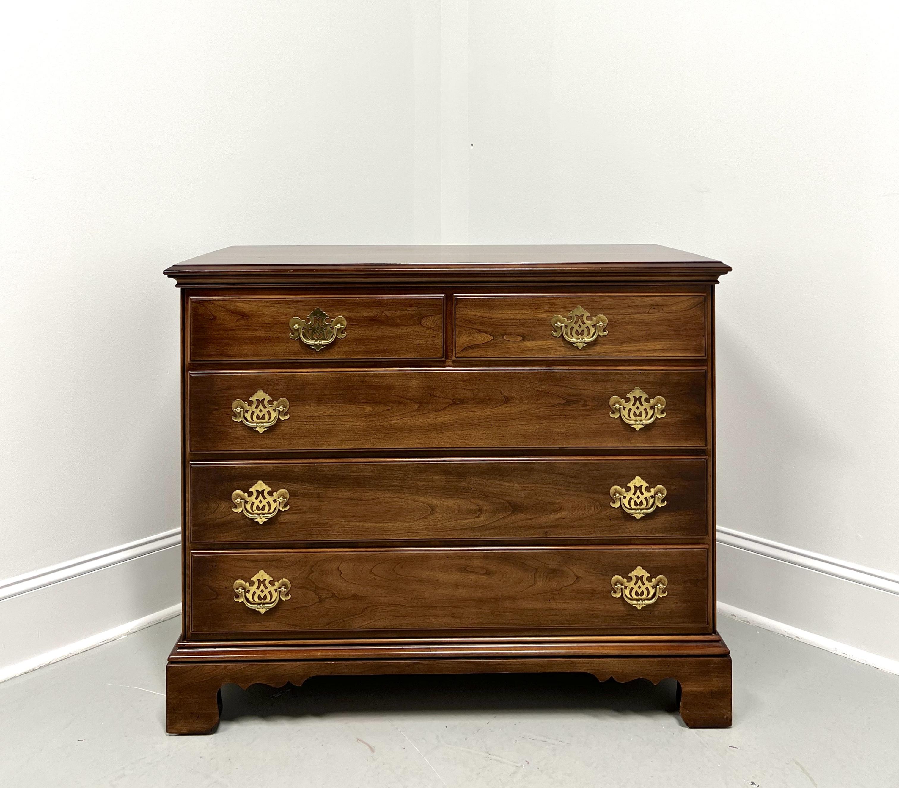 A Chippendale style bachelor chest by Statton Furniture, from their Trutype Americana line. Solid cherry wood with their Oxford finish, bevel edge to the top, decorative brass hardware, and bracket feet. Features two smaller over three larger